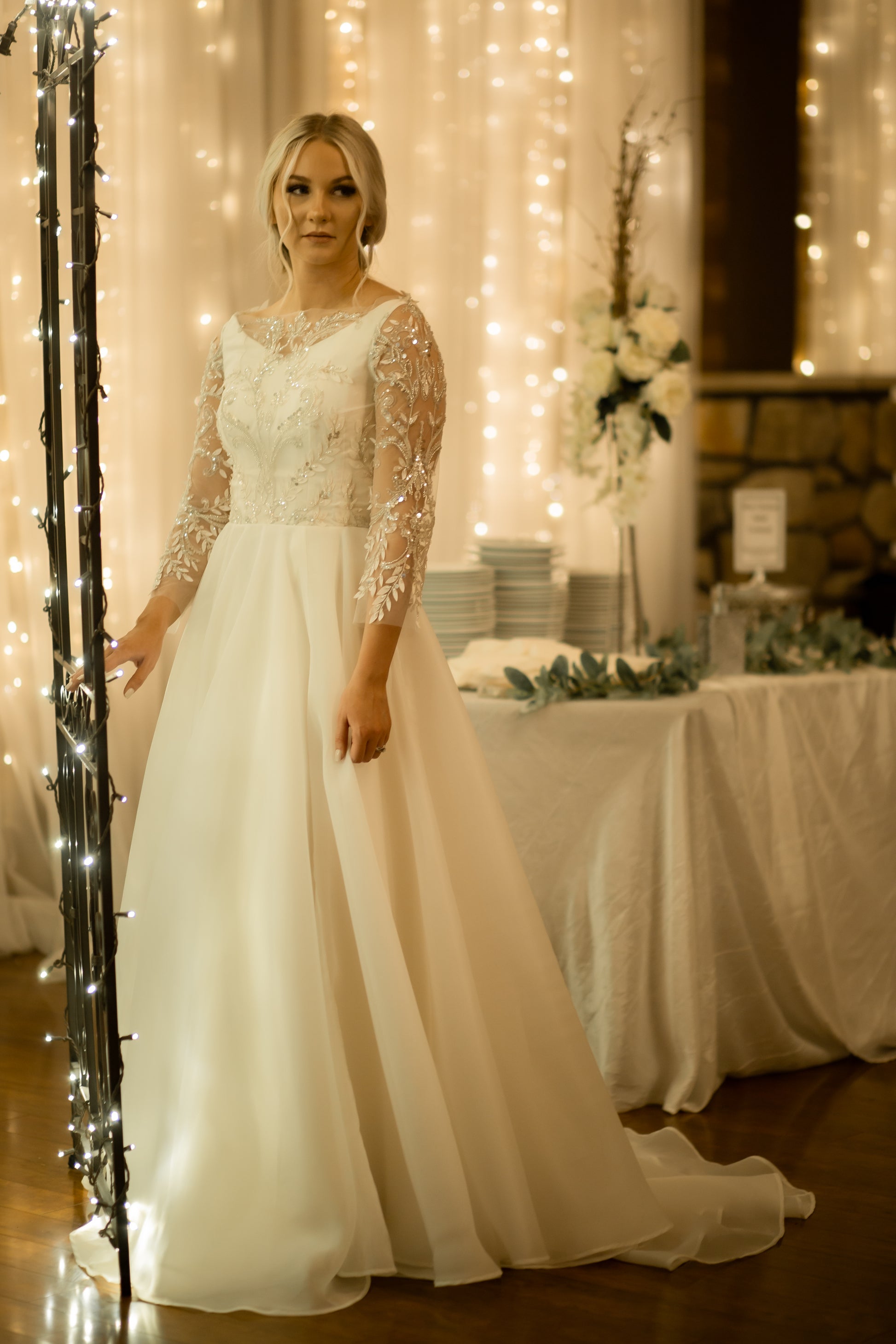 A shot of the Theodora gown from the front angle on a bride, in this full length shot  the A-line silhouette with shimmer lace and the full organza skirt are the focus.