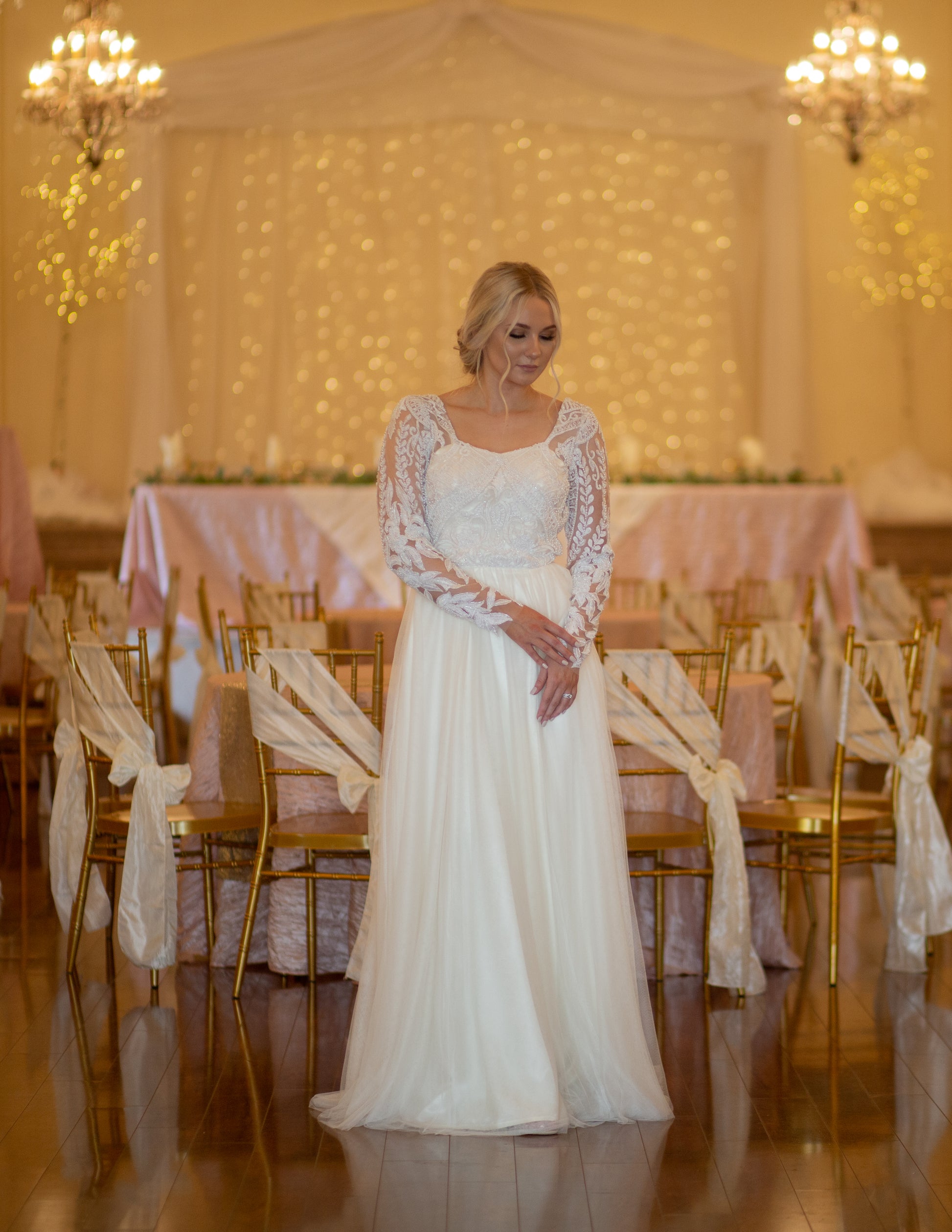 Full front image of Farrah gown on  a bride, showing long lace sleeves, square neckline, and soft tulle skirt