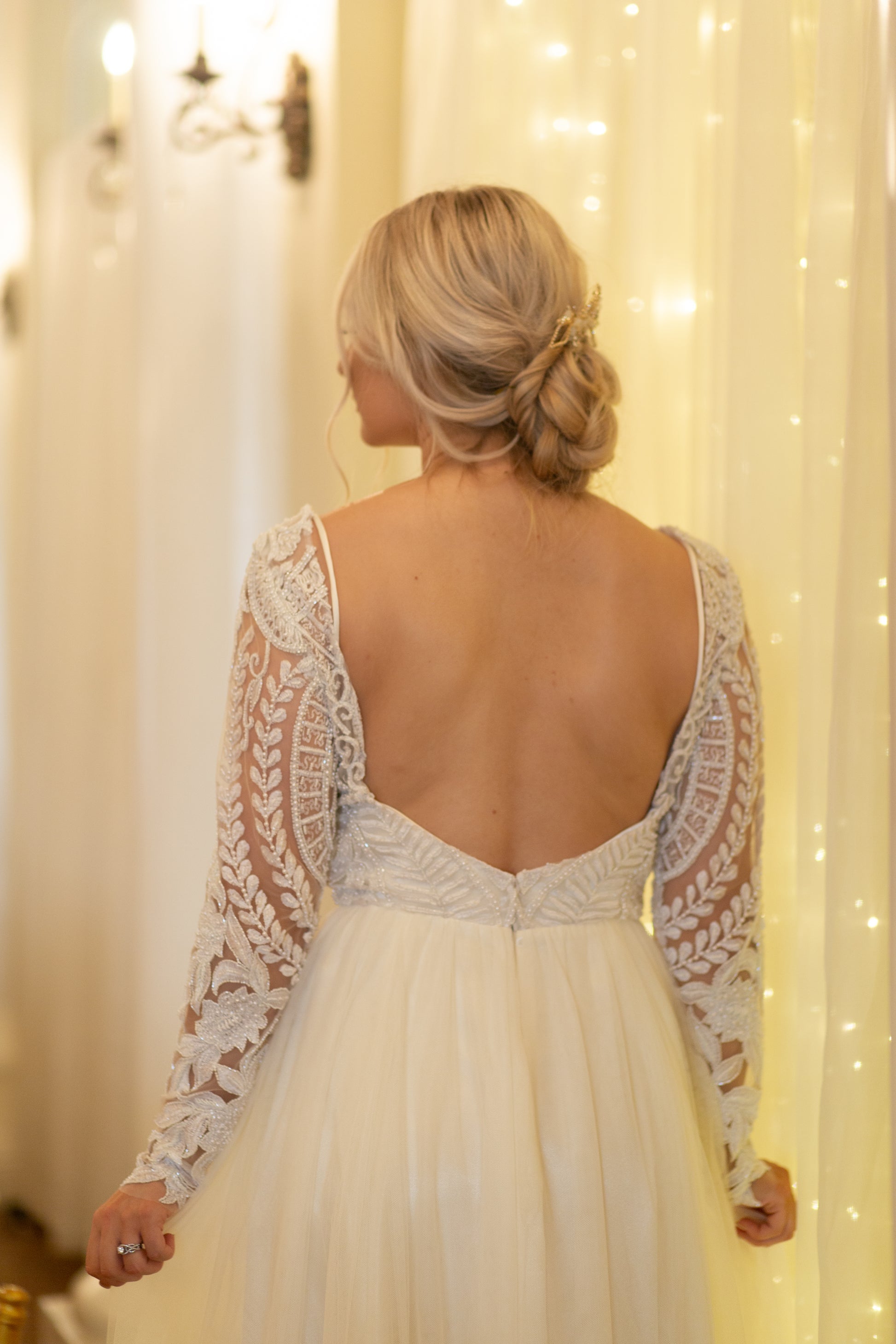 Close up of the back bodice on a bride. Shows off the low cut back and sleeve design.