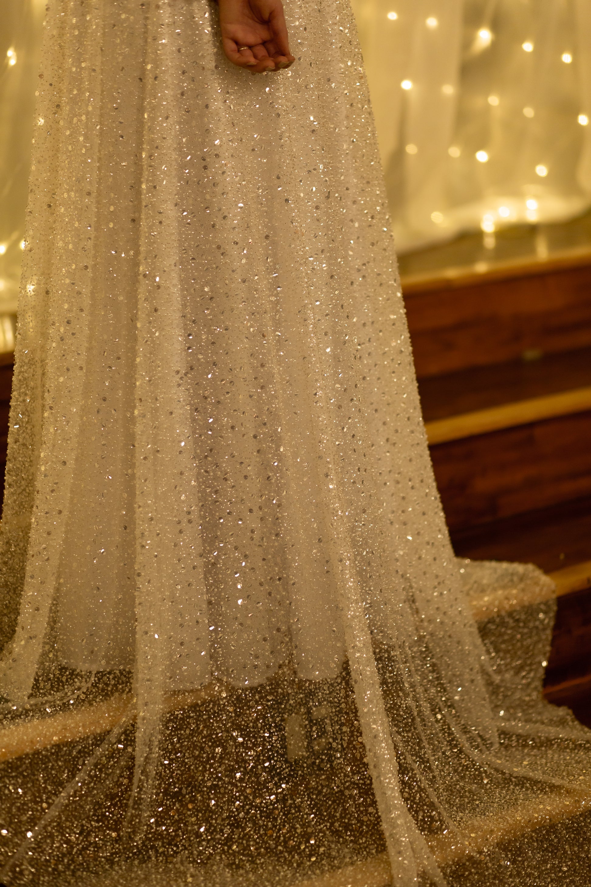 Dramatic shot of bride on stairs, showcasing 20” beaded overlay train trailing behind and down the steps.