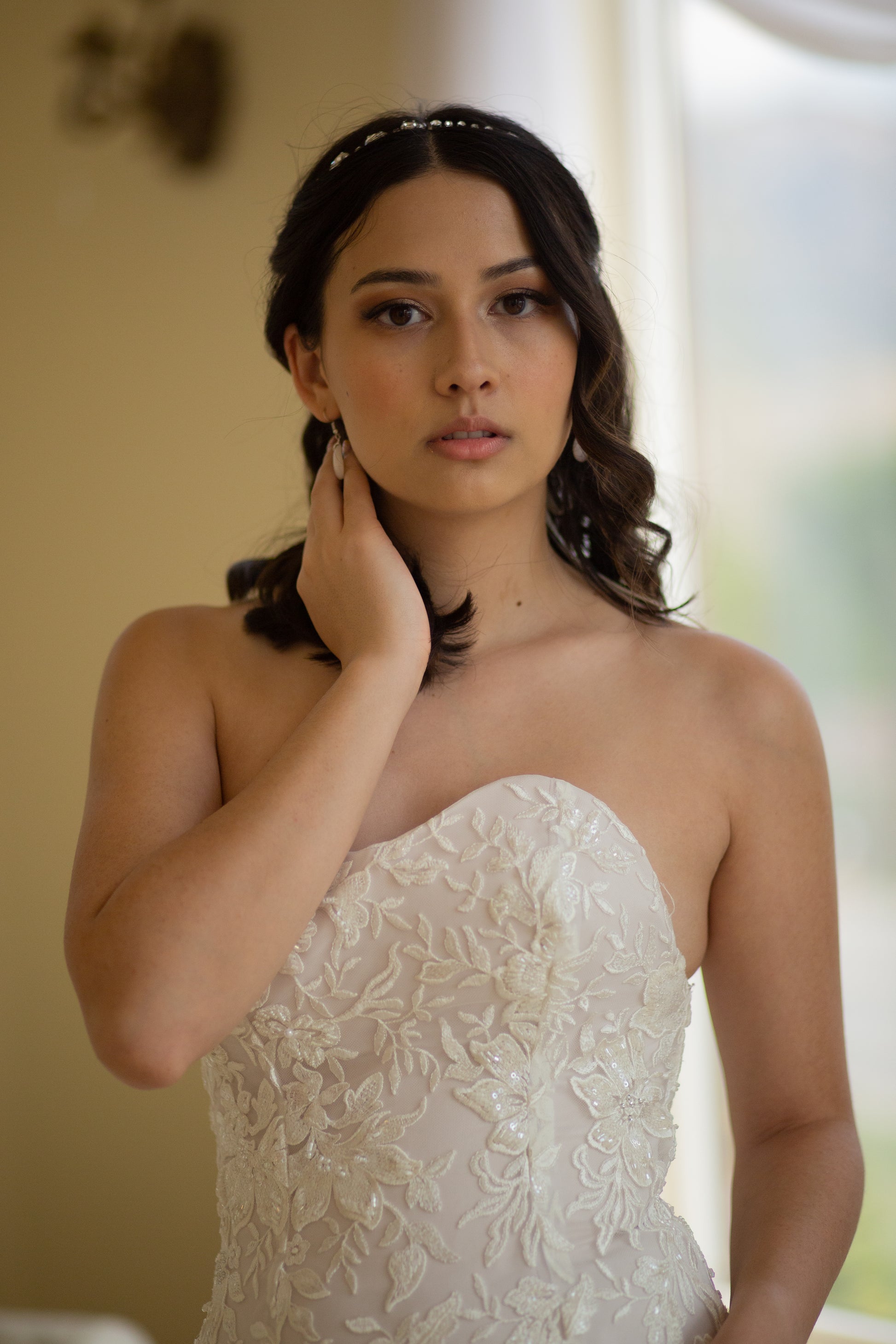 A close up photo of a bride wearing the Sawyer gown, the photo is of the gown from the waist up. The wedding dresses beaded lace shines in the light and shows off the sweetheart neckline and fitted bodice