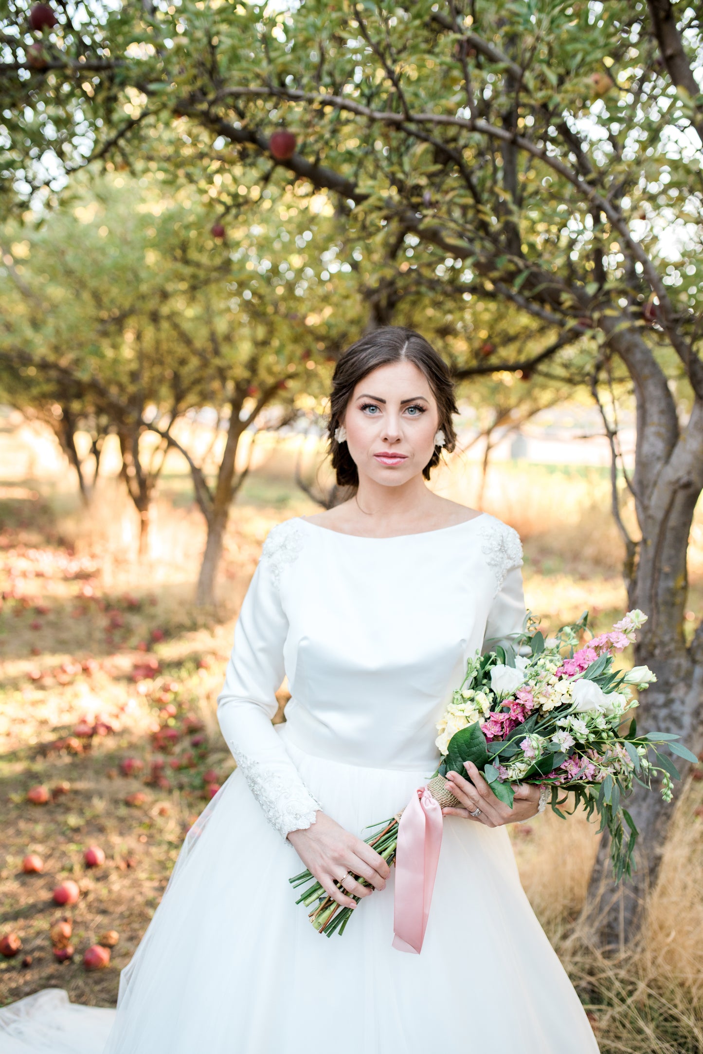 Bride standing in the Ava gown, tulle skirt flowing softly, showcasing the gown’s volume and romantic silhouette.