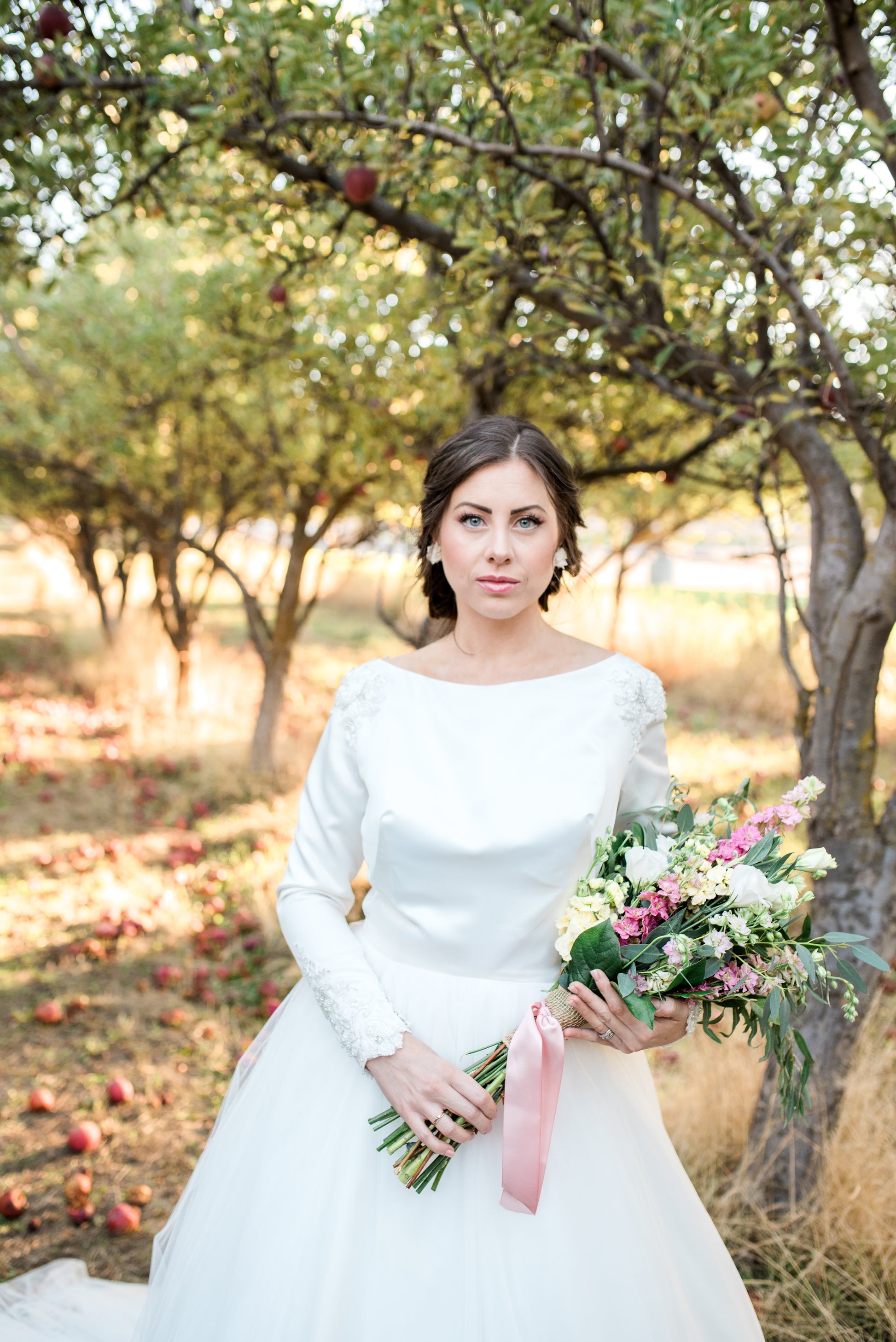 Bride standing in the Ava gown, tulle skirt flowing softly, showcasing the gown’s volume and romantic silhouette.