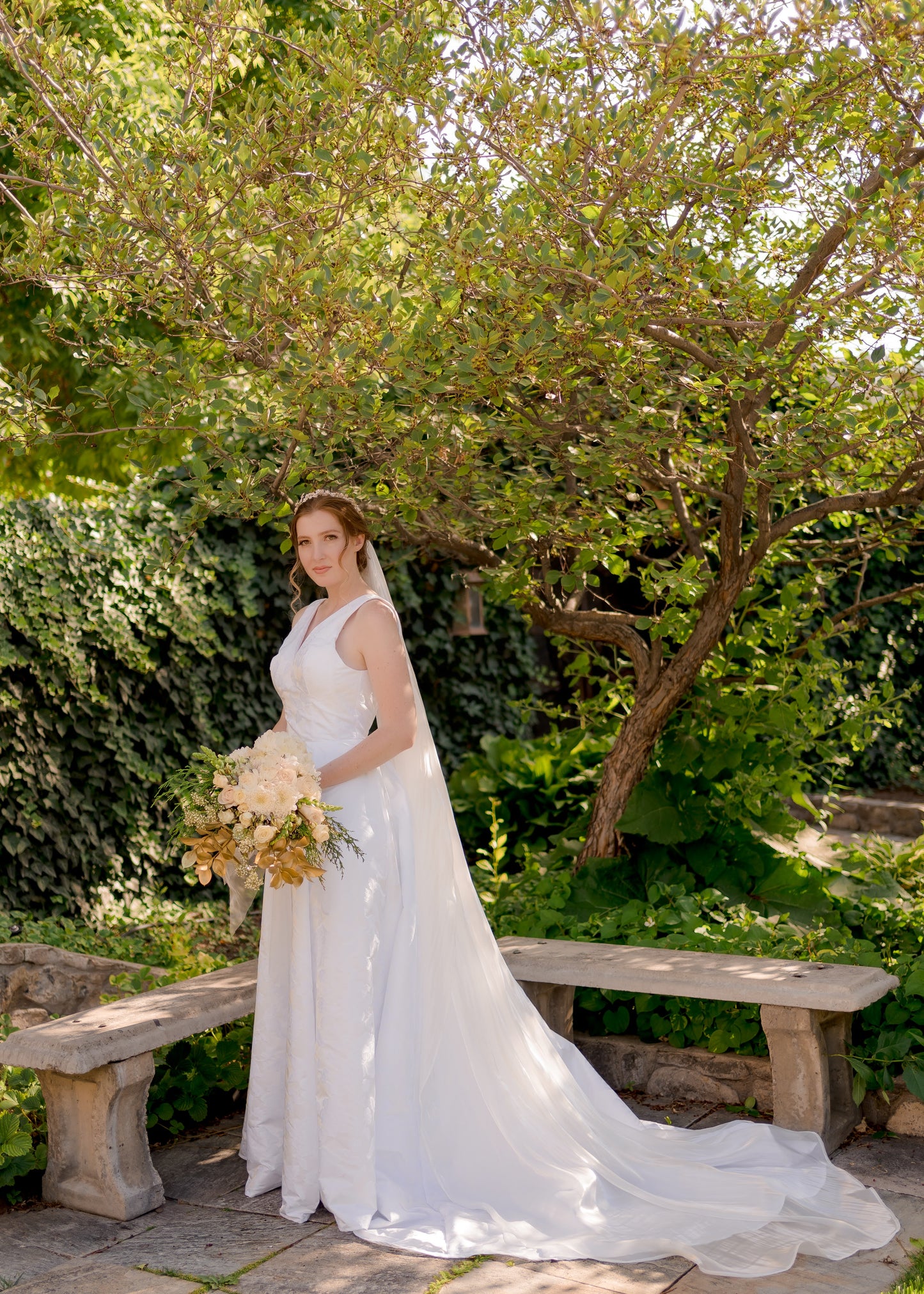 A bride wearing the flowing organza bridal veil, cara, with fluid movement and a clean edge as it flows behind the bride. It is styled here with our Madison gown.