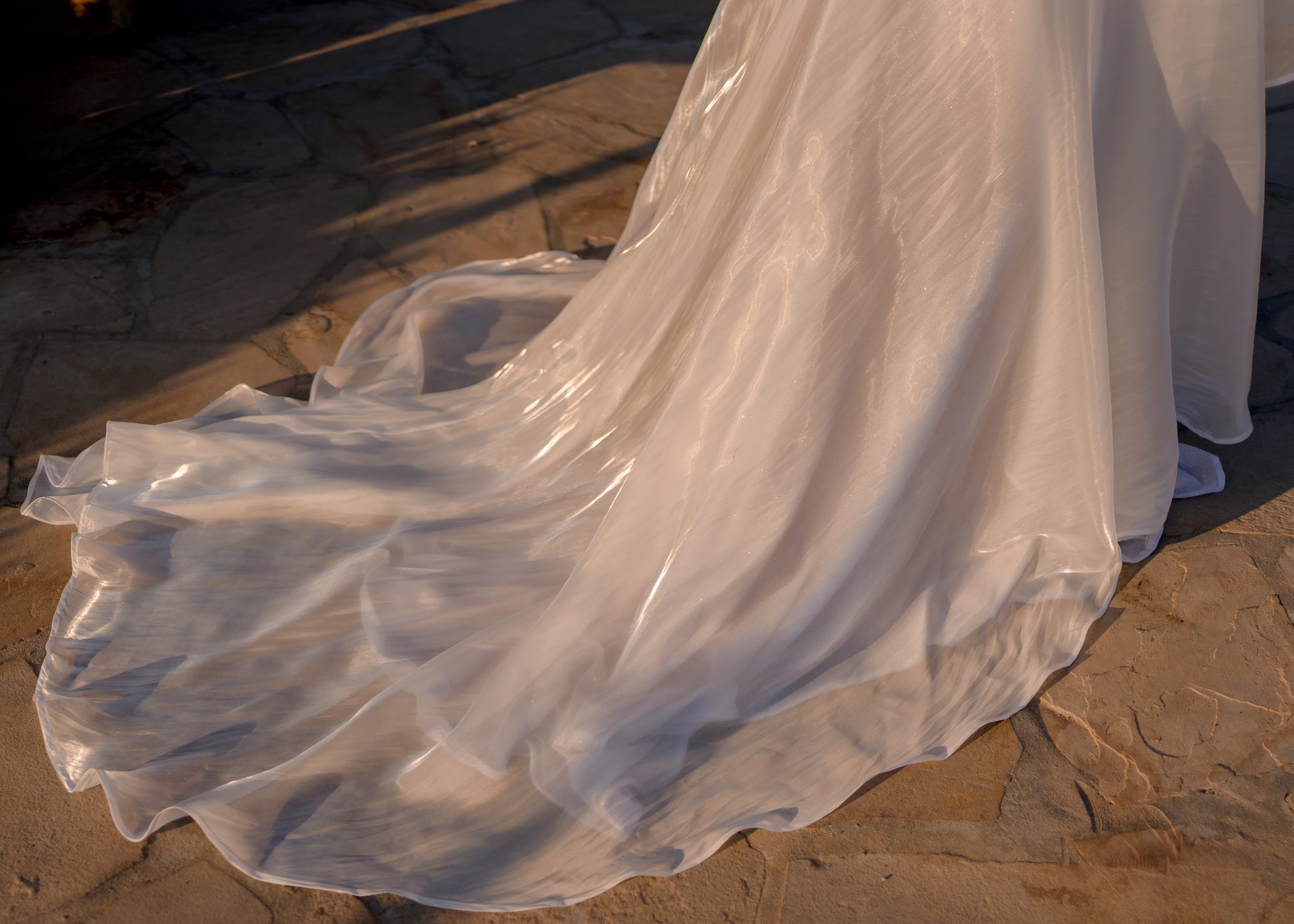 Close-up of pale ivory organza fabric on the Amber skirt, reflecting light with a subtle sheen like flowing water.