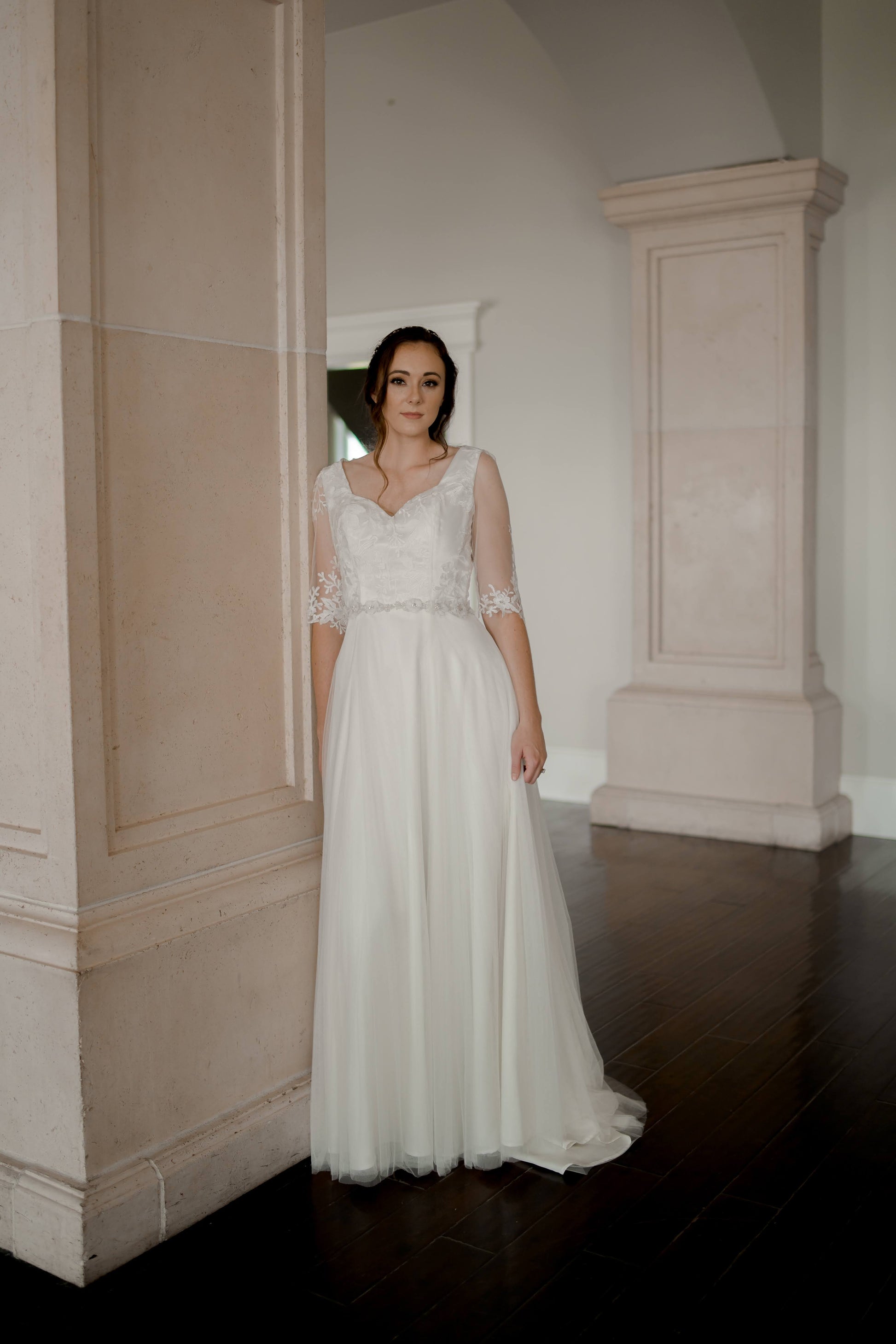 A full length photo of a bride in a wedding gown that has been paired with our heidi belt.