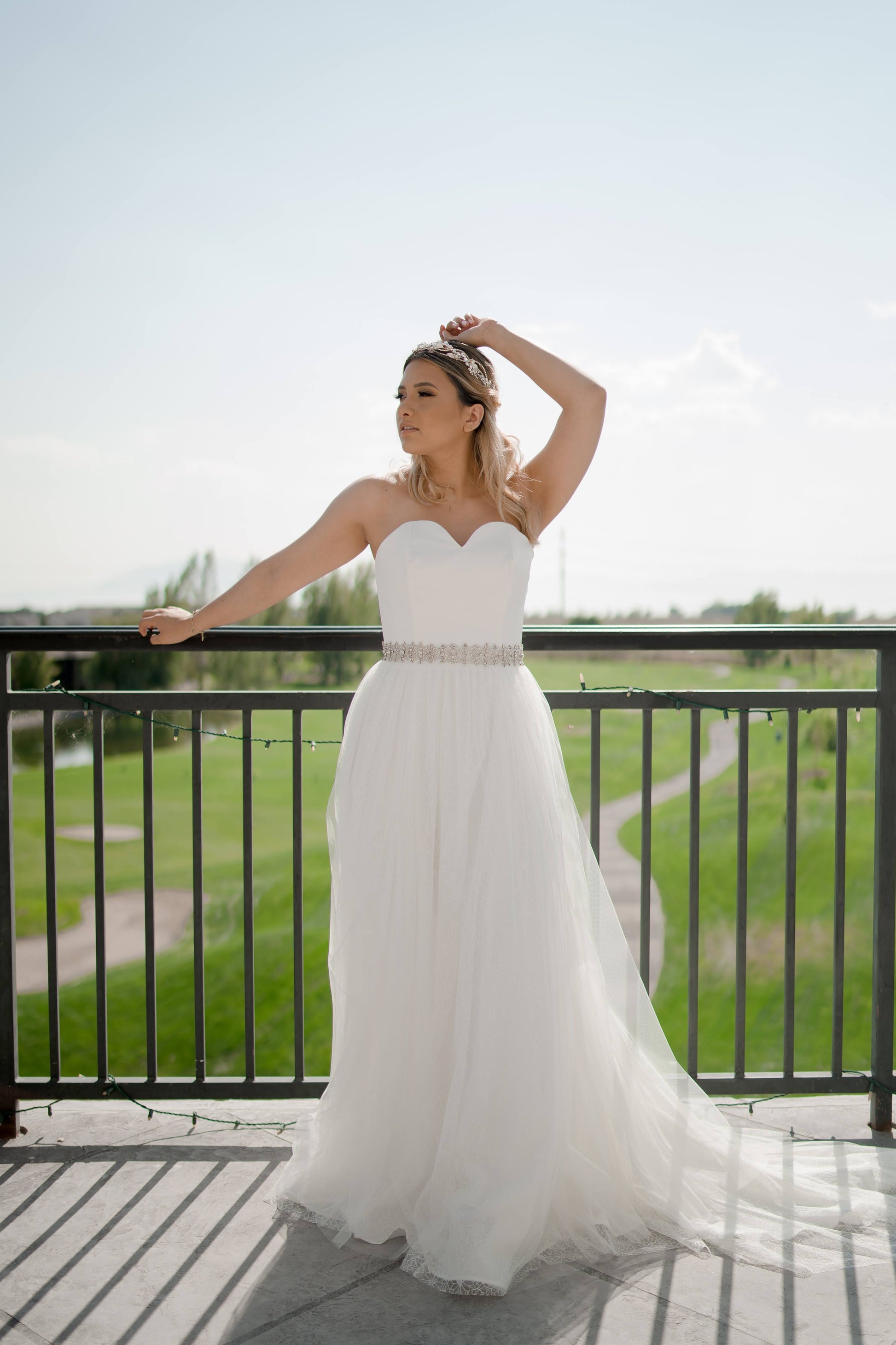 A full length shot of a bride wearing the beaded rhinestone sasha bridal belt and the Beatrice gown.