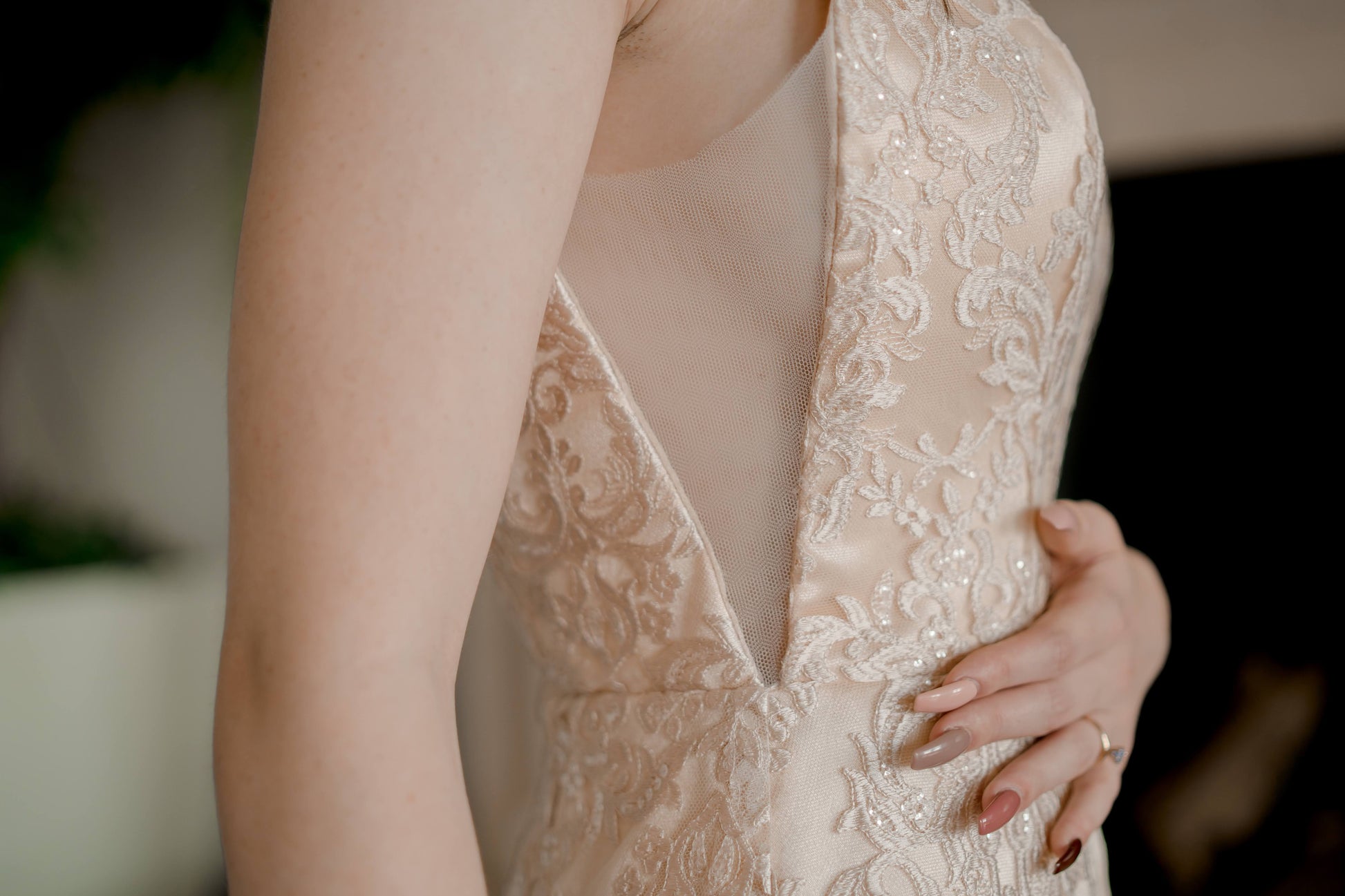 A close up of the illusion cut out on the Margaret trumpet gown shown here in champagne. The cut out shows a slight amount of side bust.
