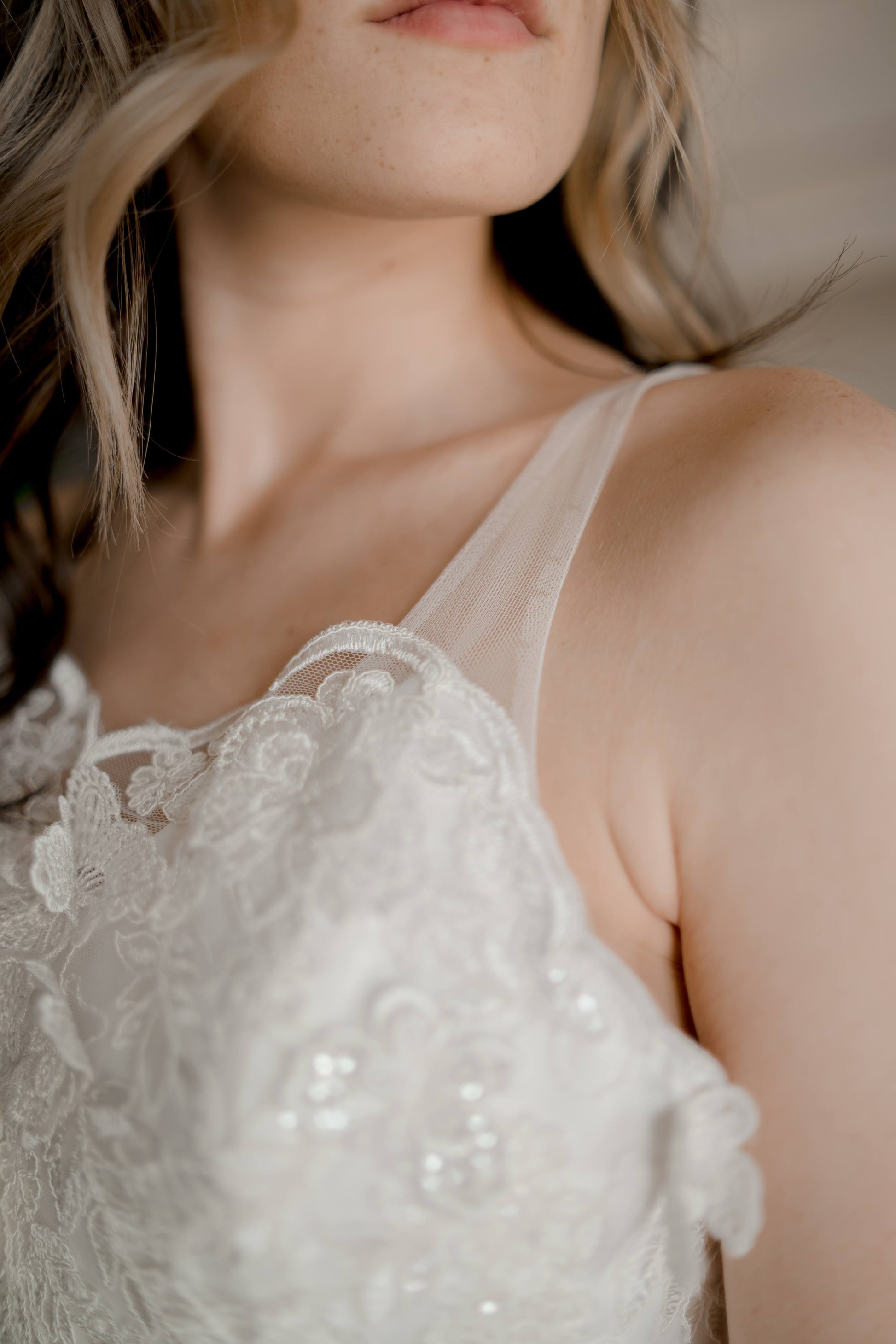 A close up shot of the scalloped neckline edge, illusion strap and 3d butterfly lace.