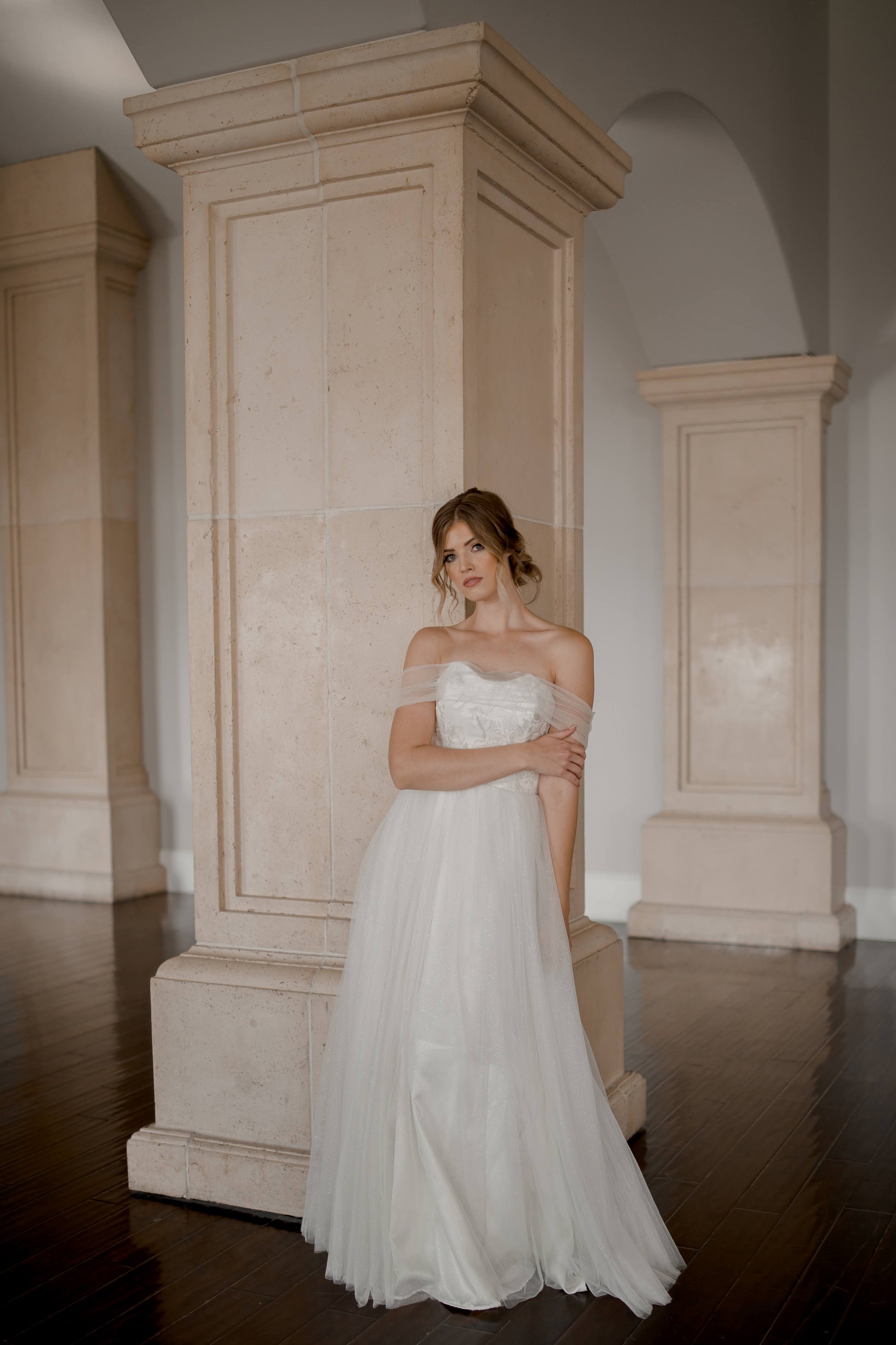 A styled shot of a bride wearing the penelope gown, the gown has a swooped sweetheart neckline, full tulle skirt, and no train.