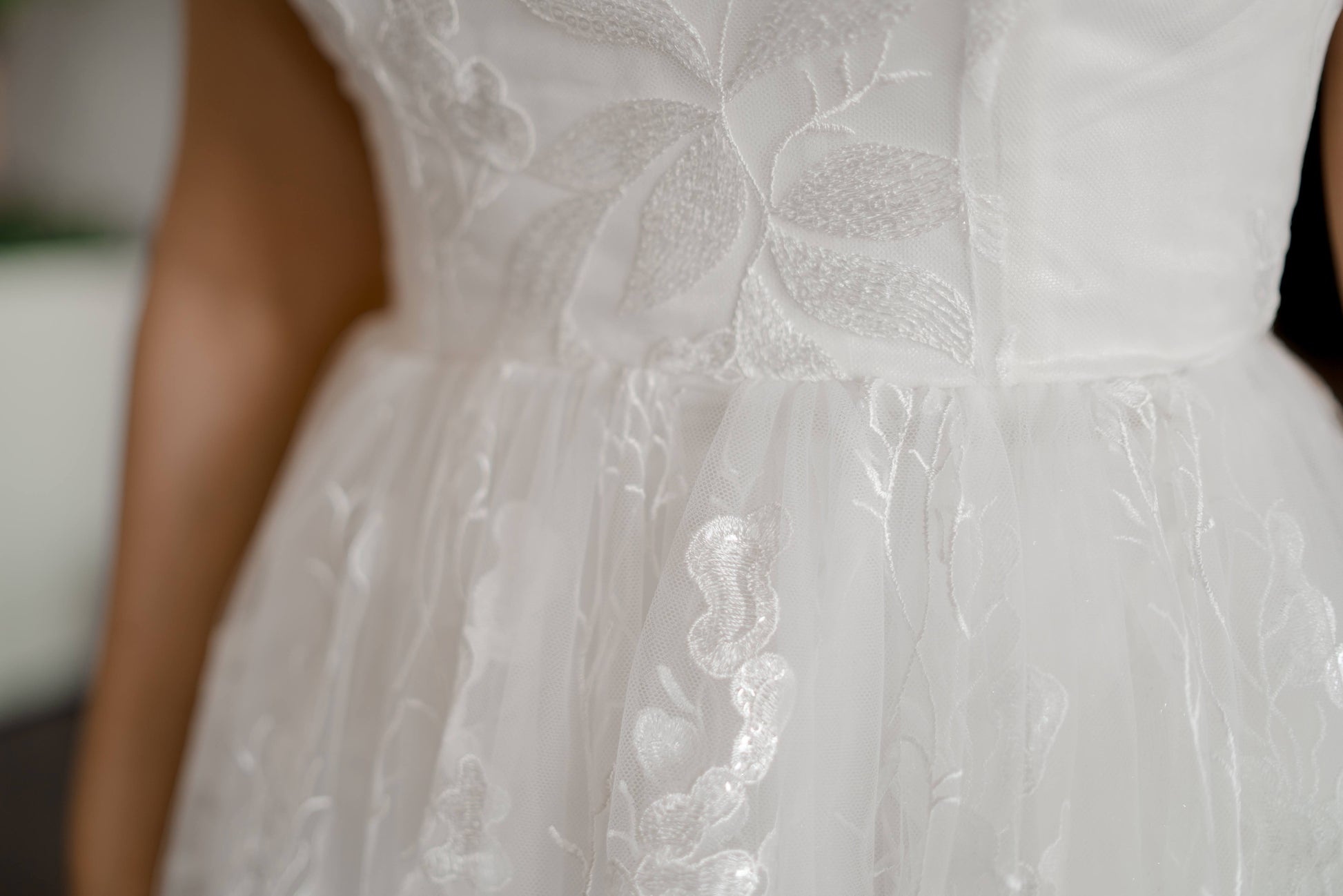 A close up of the waist seam  of the Rosie wedding dress with a satin base gown, sequin lace overlay and gathered lace skirt.