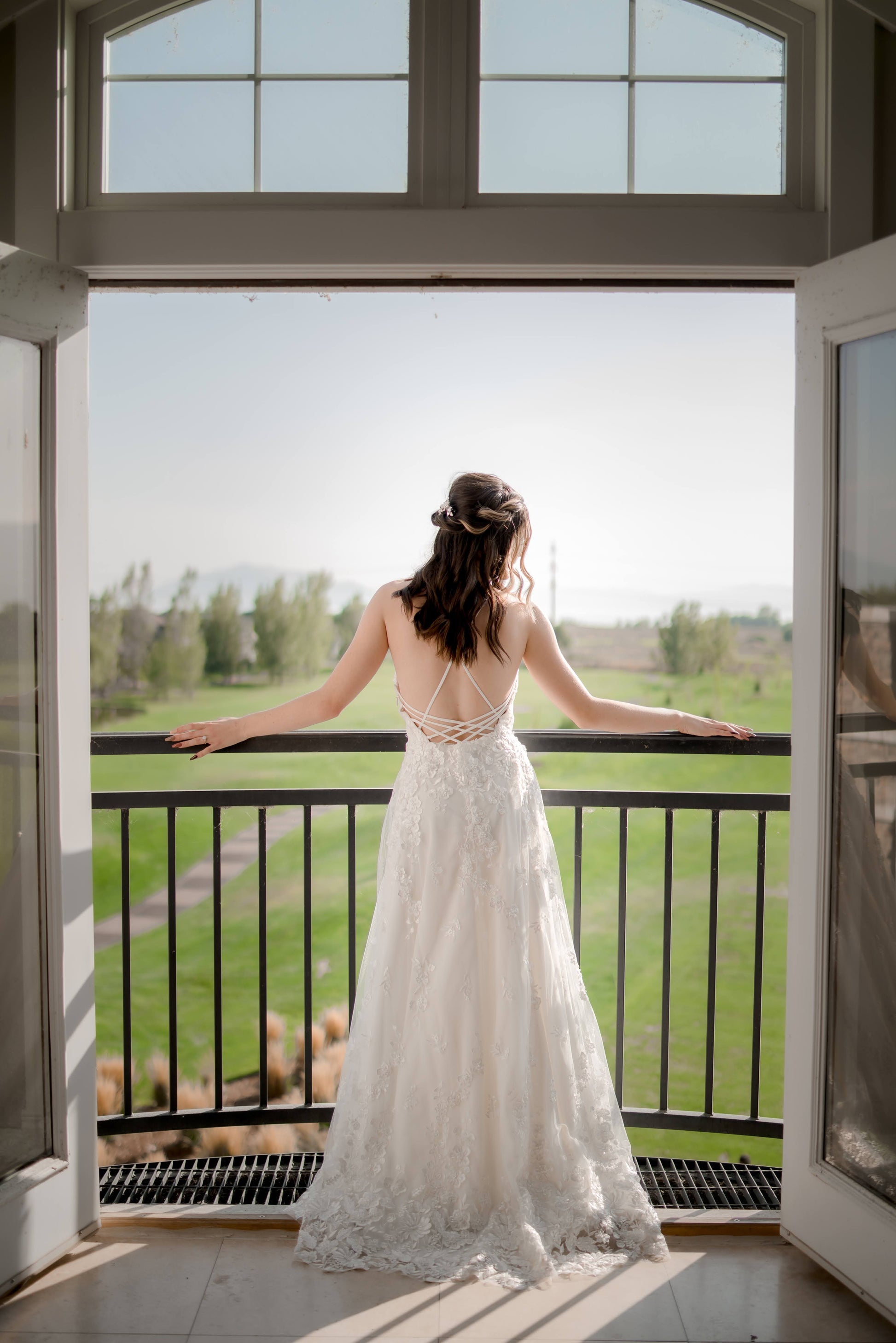A full length shot from the back of the Wilhelmina wedding gown; the low strappy back and small train are on display.