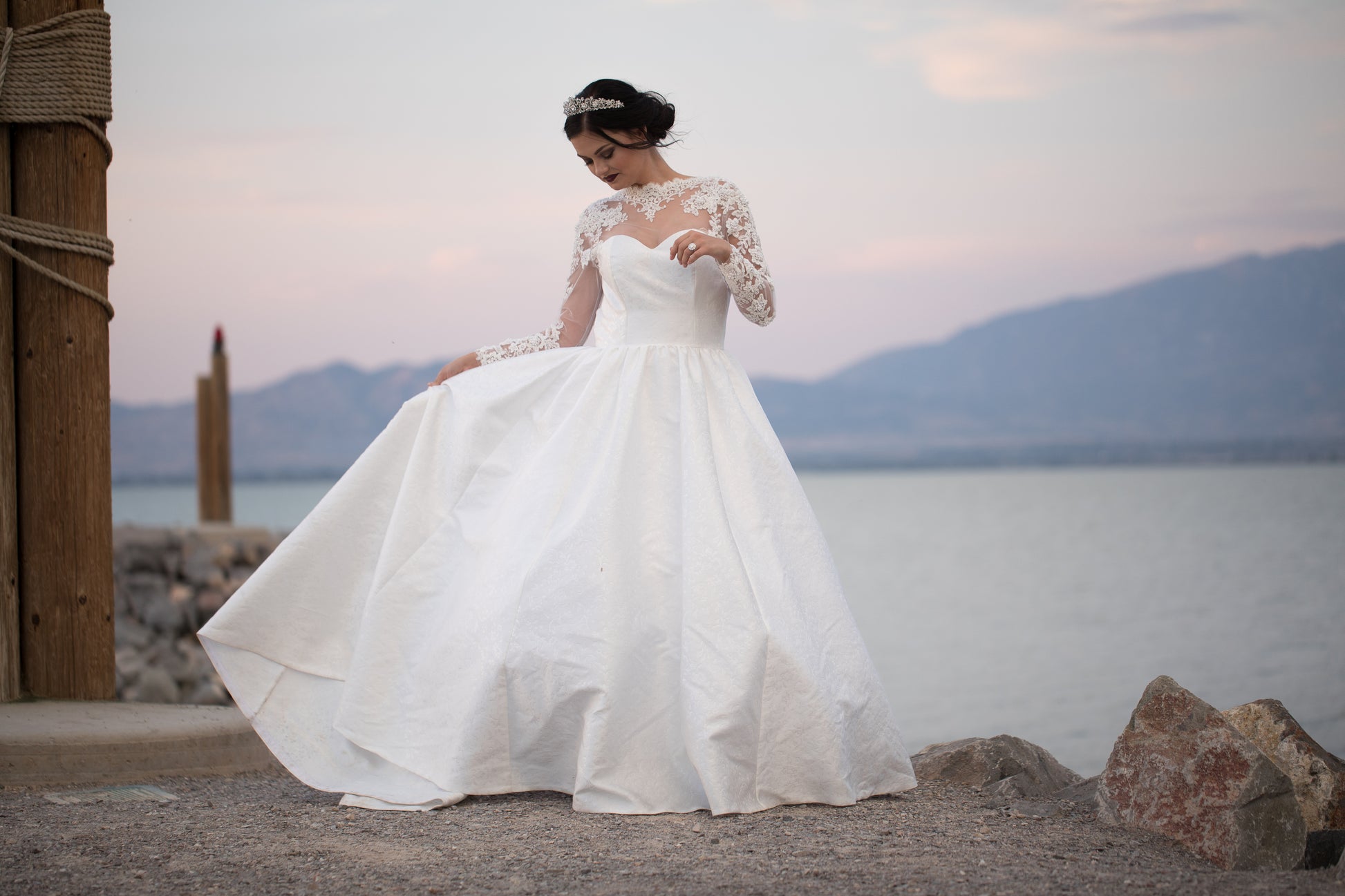 Full front photo of a bride wearing gemma and holding out the skirt like shes dancing.