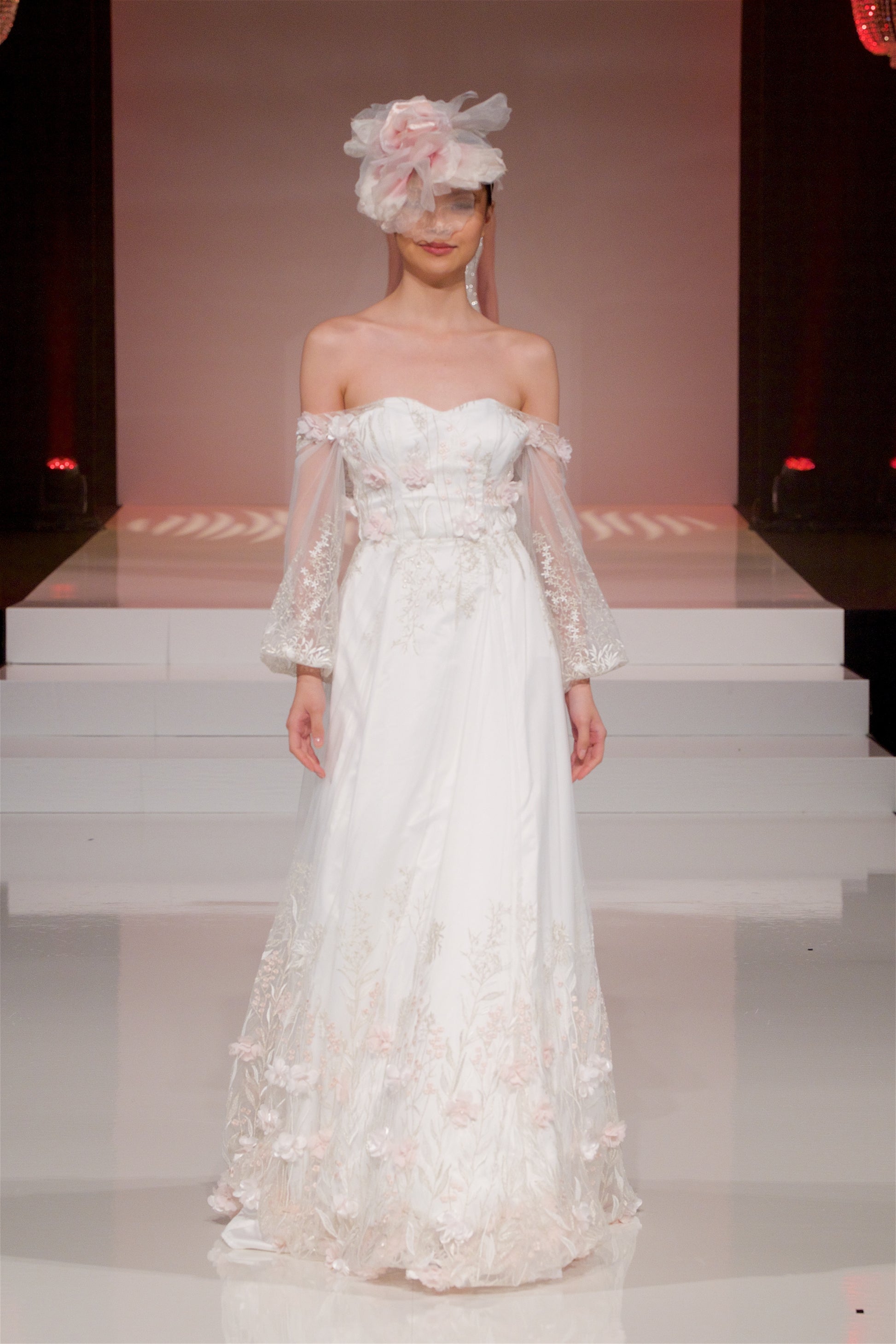 A straight on shot of the prue gown on a catwalk; the skirt moves as she walks forward flowing natrually.