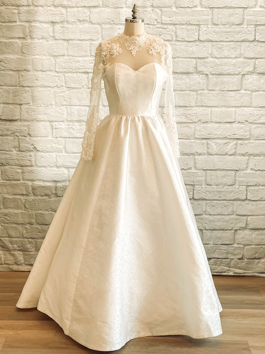 Full front of Gemma wedding dress showing metallic jacquard skirt, illusion lace sleeves, and sweetheart neckline