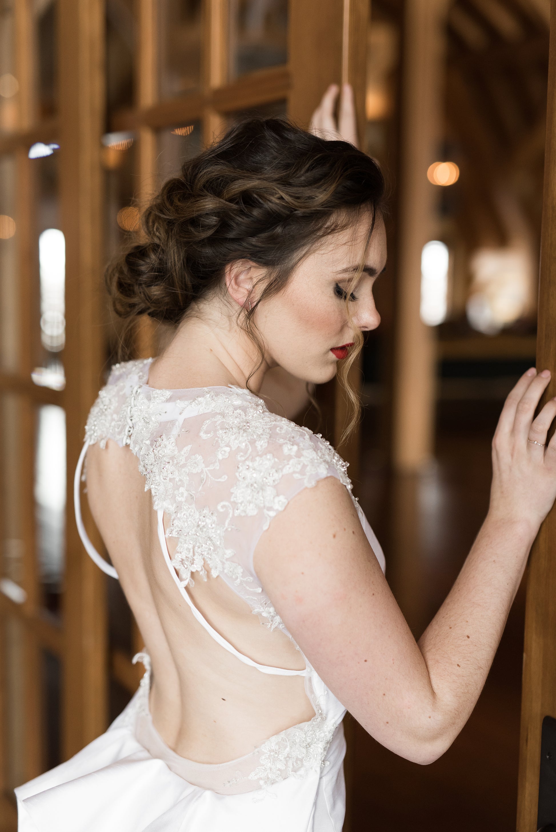 A close up of the shoulders and keyhole from the back of the mia gown. The beaded lace, draped straps and low back are in focus. 
