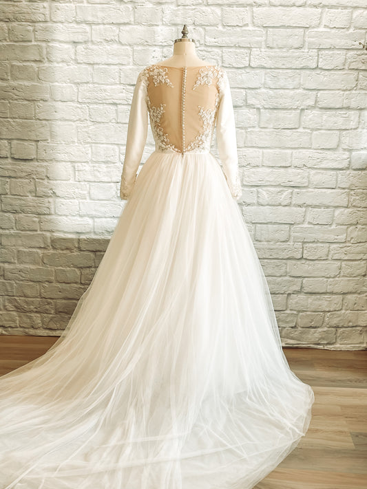 Full back view of the Ava wedding dress showing illusion tulle framed by floral lace, satin-covered buttons, and a long tulle train.