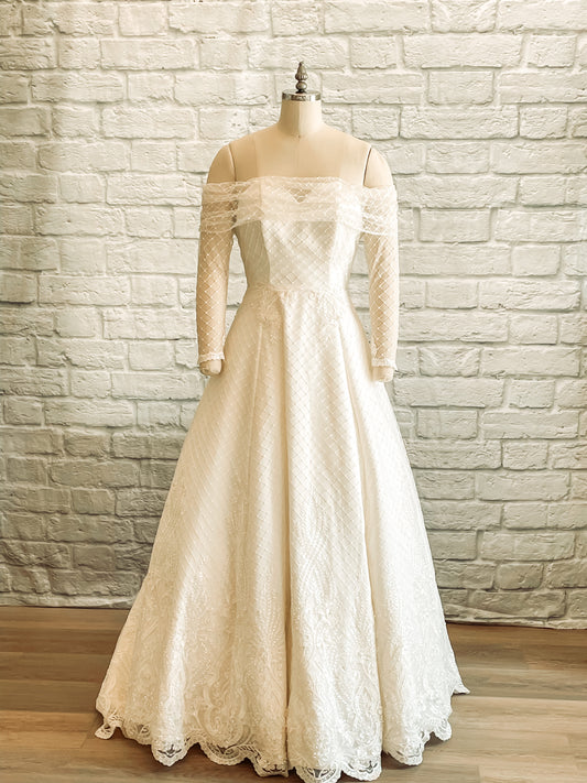 The wedding gown, Virginia, on a mannequin; the full front view shows the Virginia gowns sweetheart bodice and Bardot diamond tullé sleeves.