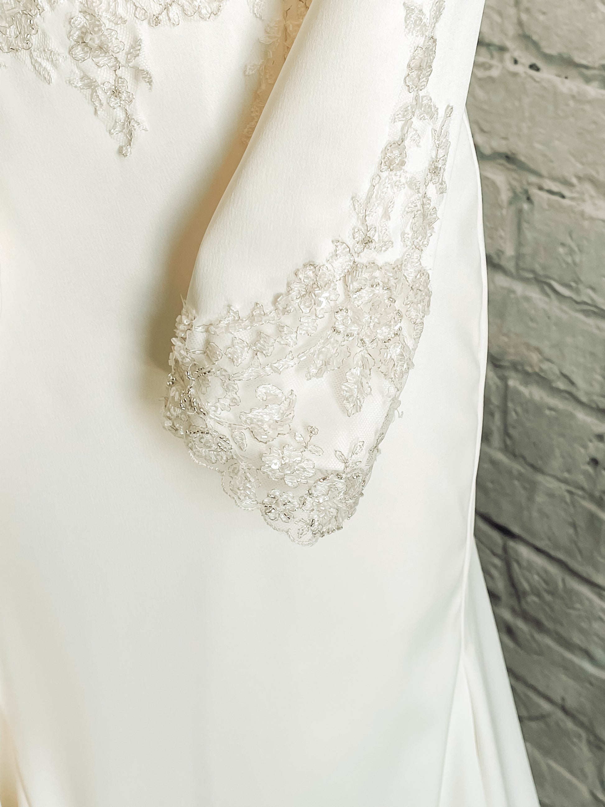 Close-up of intricate lace trim at the cuff of the long sleeve.