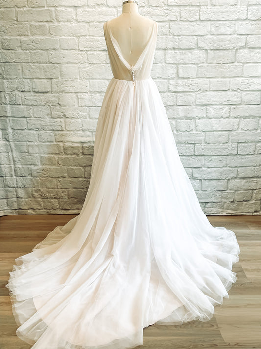 Persephone bridal gown showing a full back view with a dramatic cowl back with button detail and long train.
