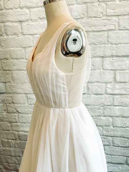 Side view of the persephone wedding gown's bodice, showing the transition between the satin lined portion of the bodie and the sheer back bodice. 