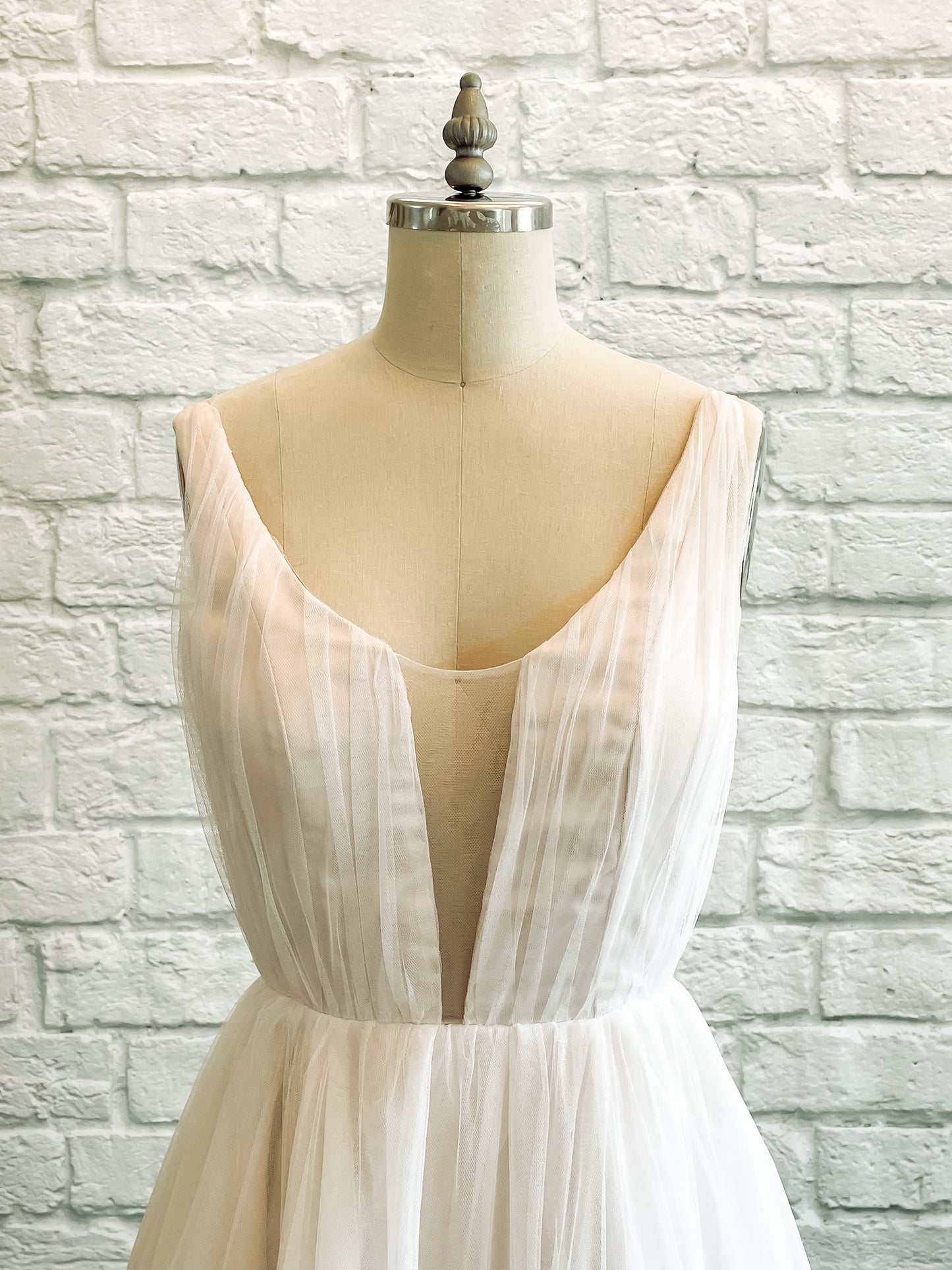 Close up of the persephone wedding dresses front bodice with Gathered tulle ruching, tank-style straps, and plunge illusion neckline. 