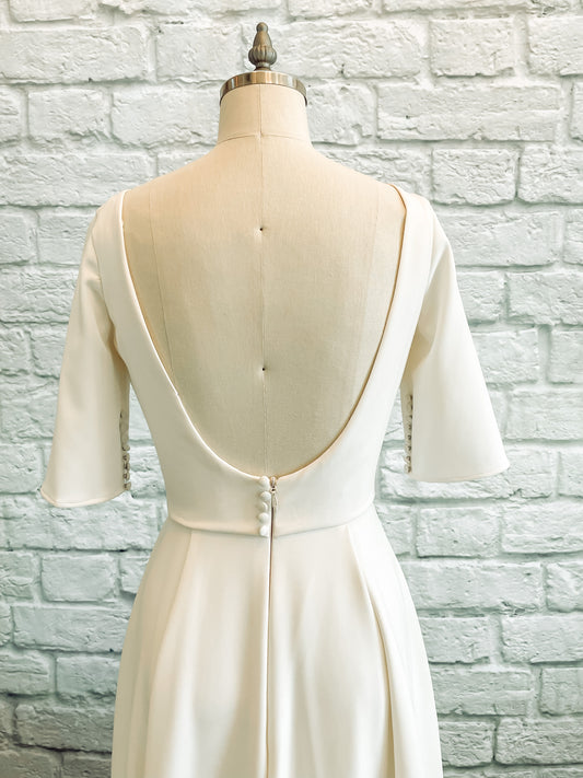 an up close photo of the back bodice of the Wendy gown; Low scoop back with faux buttons and tailored fit perfectly. 