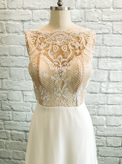 A up close shot of the front Winifred; Pale ivory lace on nude tullé back ground with a mock neck cut and scallop detail. 
