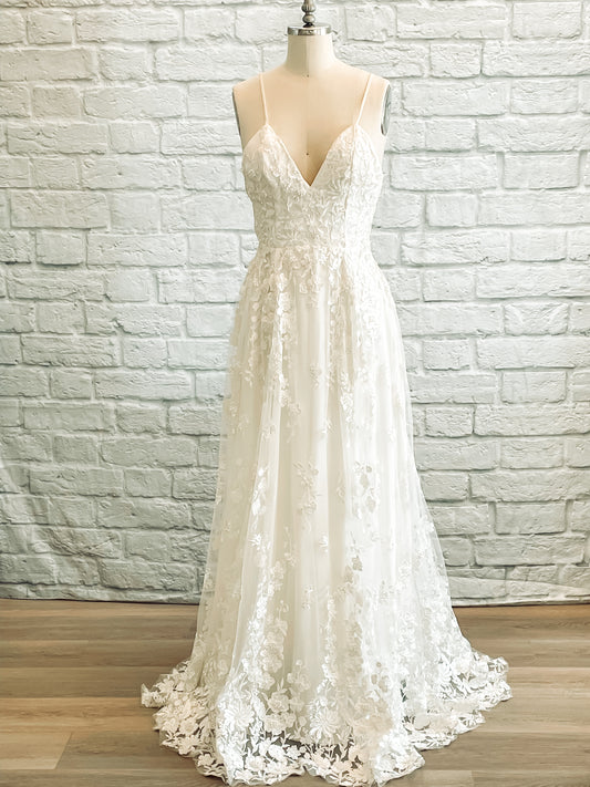 Full front view of the Wilhelmina dress on a mannequin, The Wilhelmina gown has a deep V neckline, beaded lace bodice and skirt. 