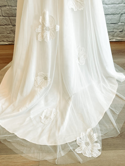 Up close shot of the tulle skirt and train; Three-layers of soft tulle cover the satin train with floral lace cascading down center back