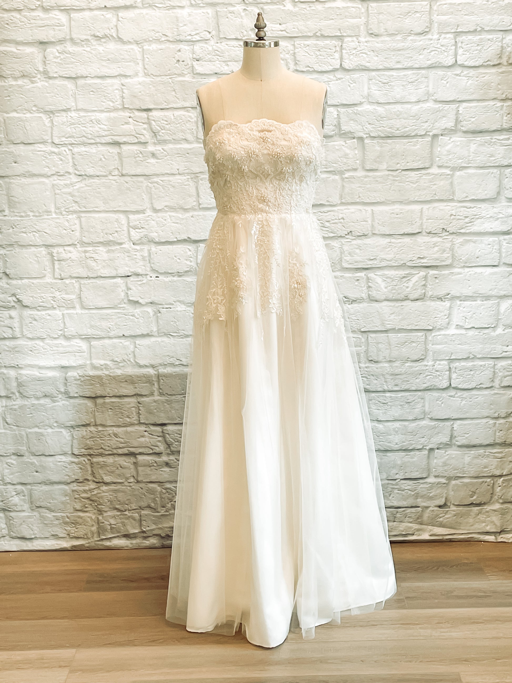 Kennsington wedding dress, on a mannequin, with strapless beaded lace bodice and soft tulle skirt.