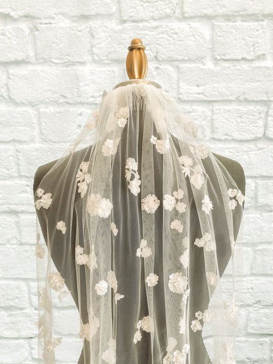 An upclose view of the Tiana veil with 3D floral appliqués and pearls. 