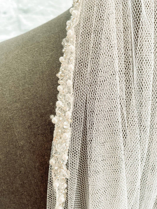 Close-up of pearl and sequin edge on Lena wedding veil that has been sewn to a soft tulle base. 