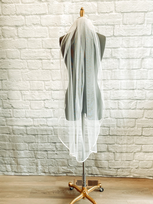 A full length shot of the Bridget veil on a mannequin in a waltz length; Simple retro wedding veil with soft satin border – Bridget