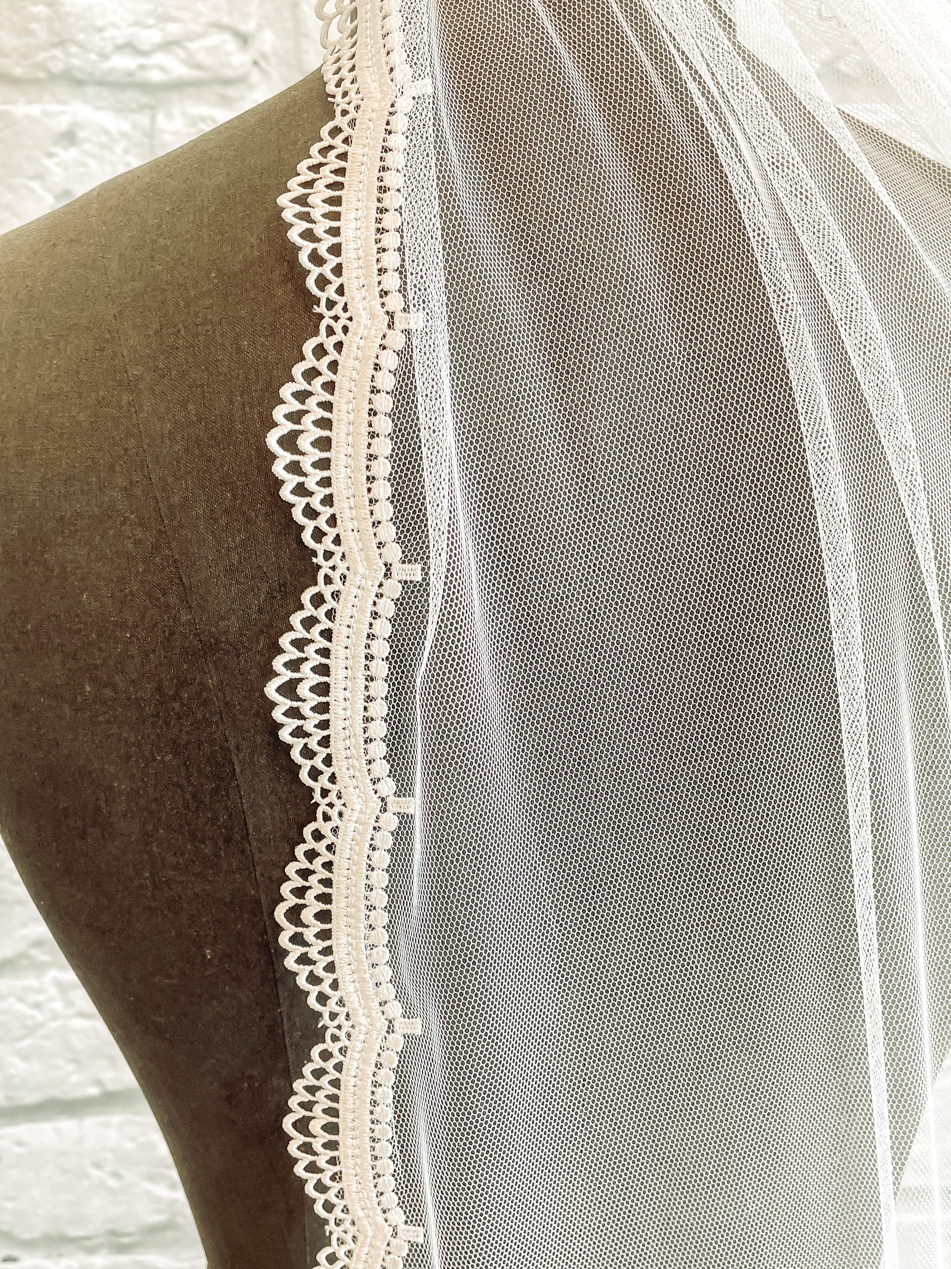 A close-up of Brennan veil scallop lace trim detail and soft tulle. 