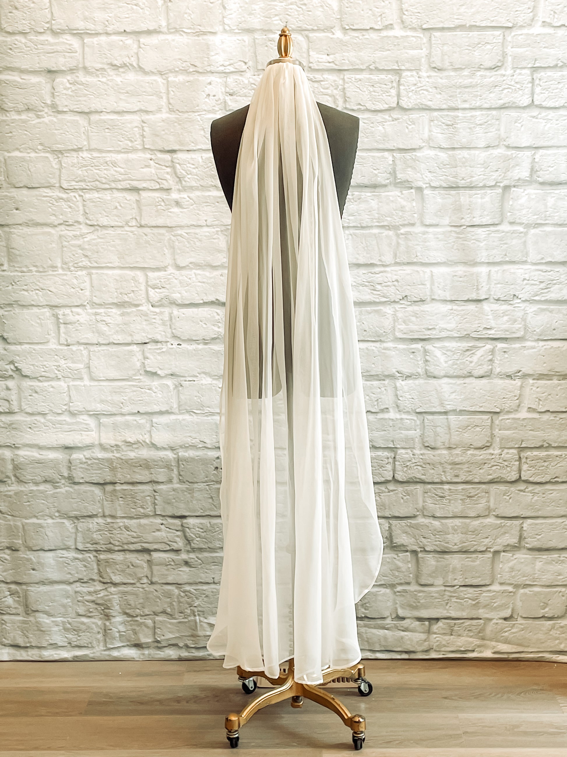 The Calf length pale ivory version of the chiffon bridal veil displayed on a mannequin. 
