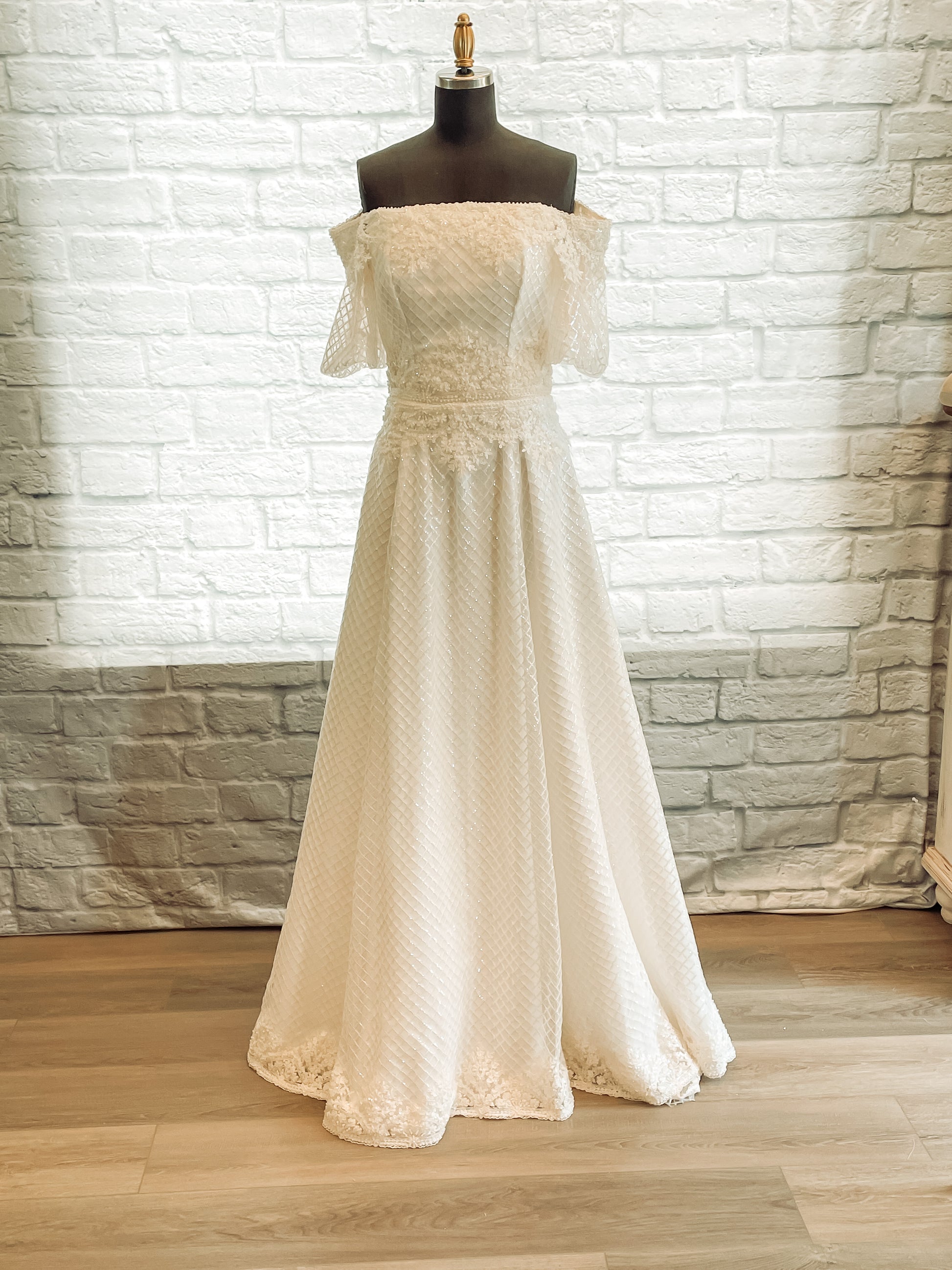 Full front view of the parker gown with diamond sequin tullé and off-shoulder puff sleeves. 