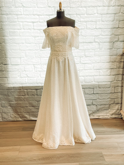 Full front view of the parker gown with diamond sequin tullé and off-shoulder puff sleeves. 