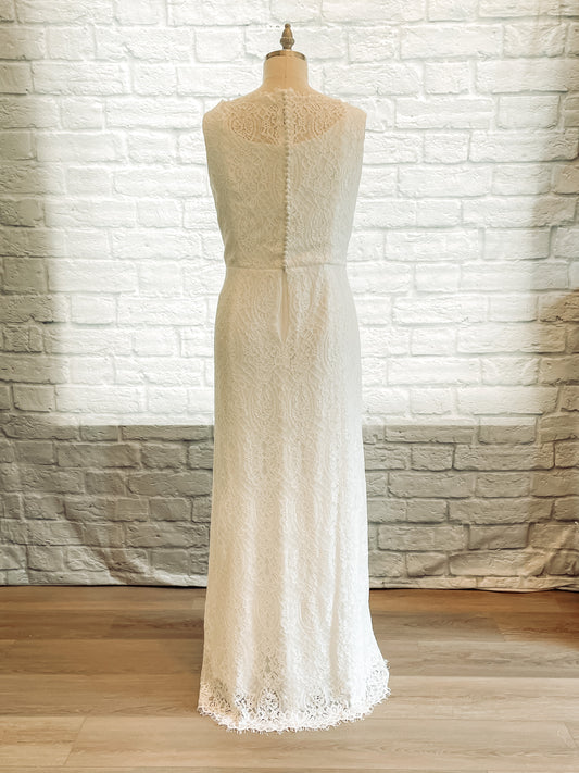 Back view of the Blair gown on a mannequin, showing satin-covered buttons running down the lace overlay to the waist.