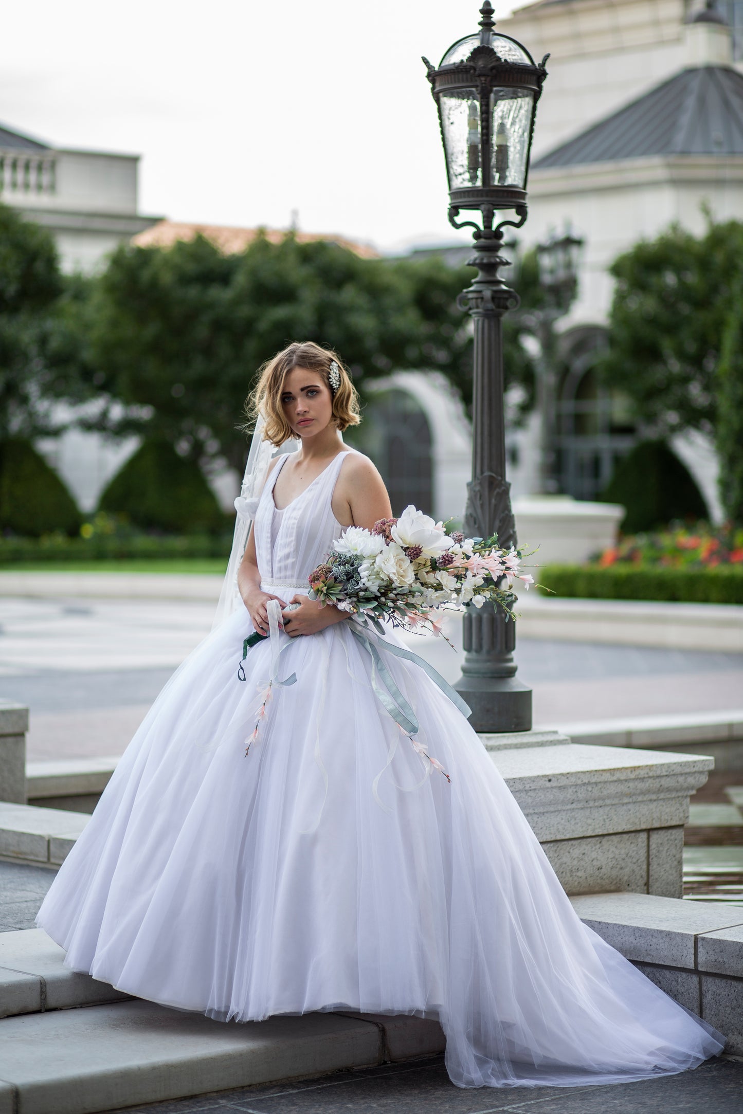 Styled photo of a bride wearing the persephone gown with a petticoat, the gown is extra full and still has a long train. 