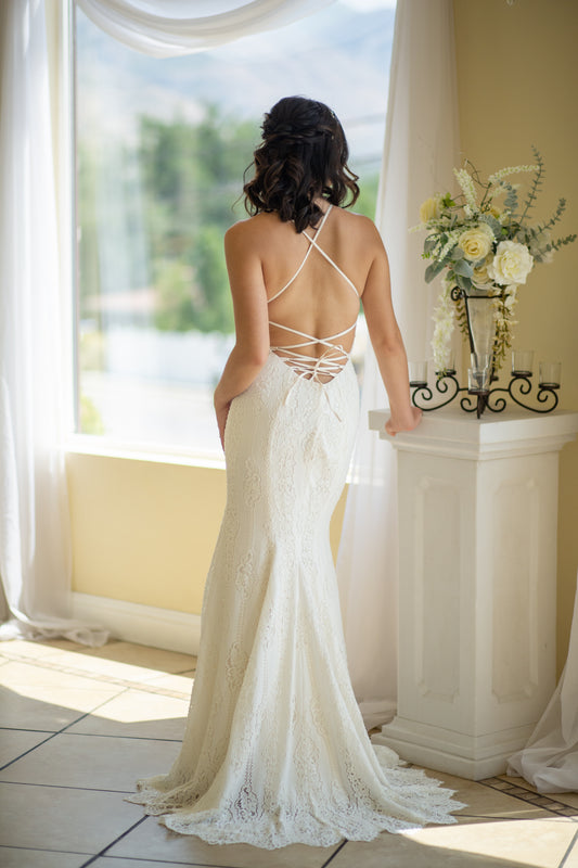 A full back view of the Willoughby gown; the fit and flare silhouette, lace up back and low scoop are featured.