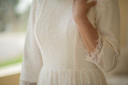 Detailed close-up of the Avabelle gown’s lace bodice and three-quarter-length sleeves, revealing the intricate rose lace, cording, and eyelash trim along the scalloped edges.