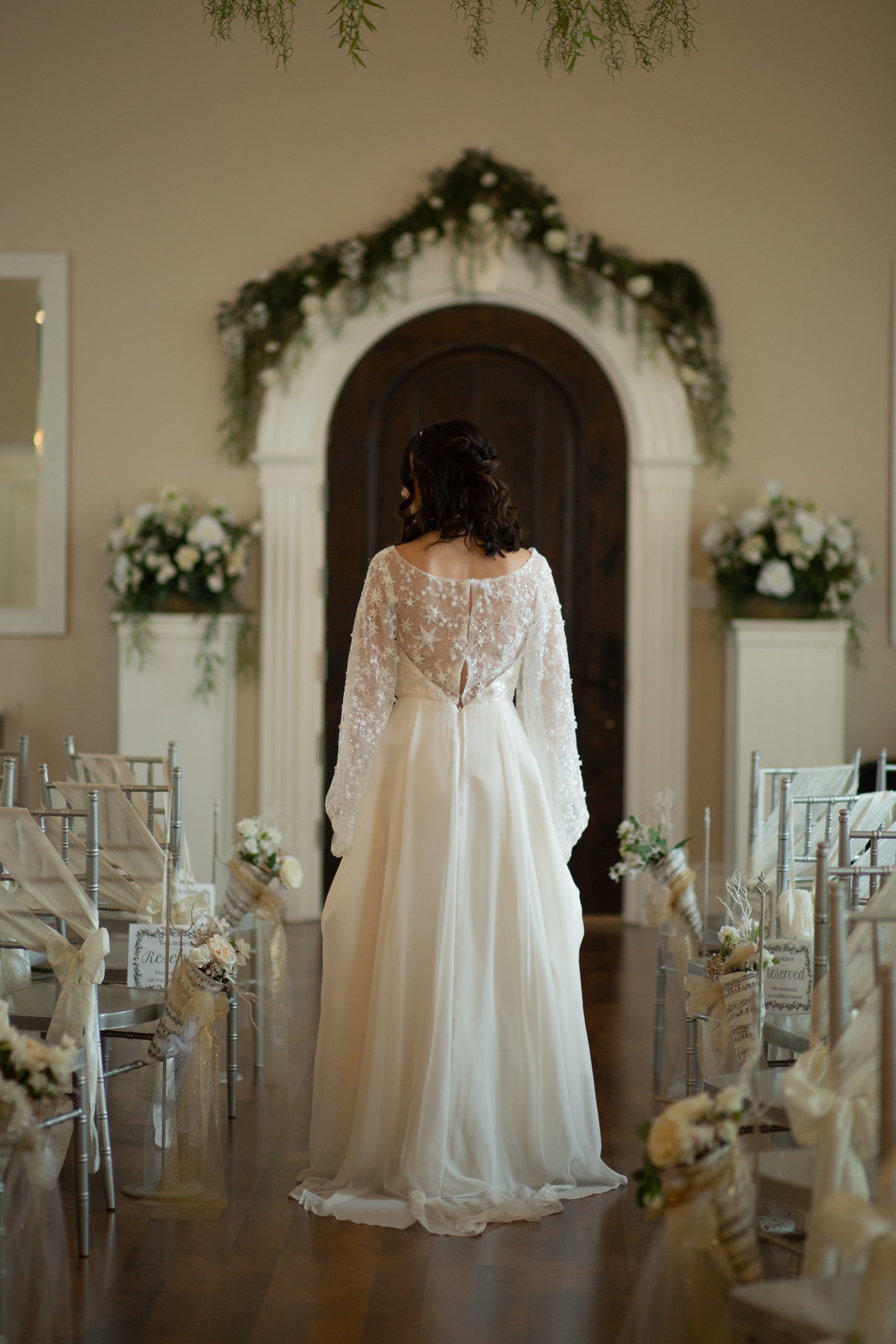 Bride facing away wearing Novelli wedding gown with star beaded lace and chiffon overlay 