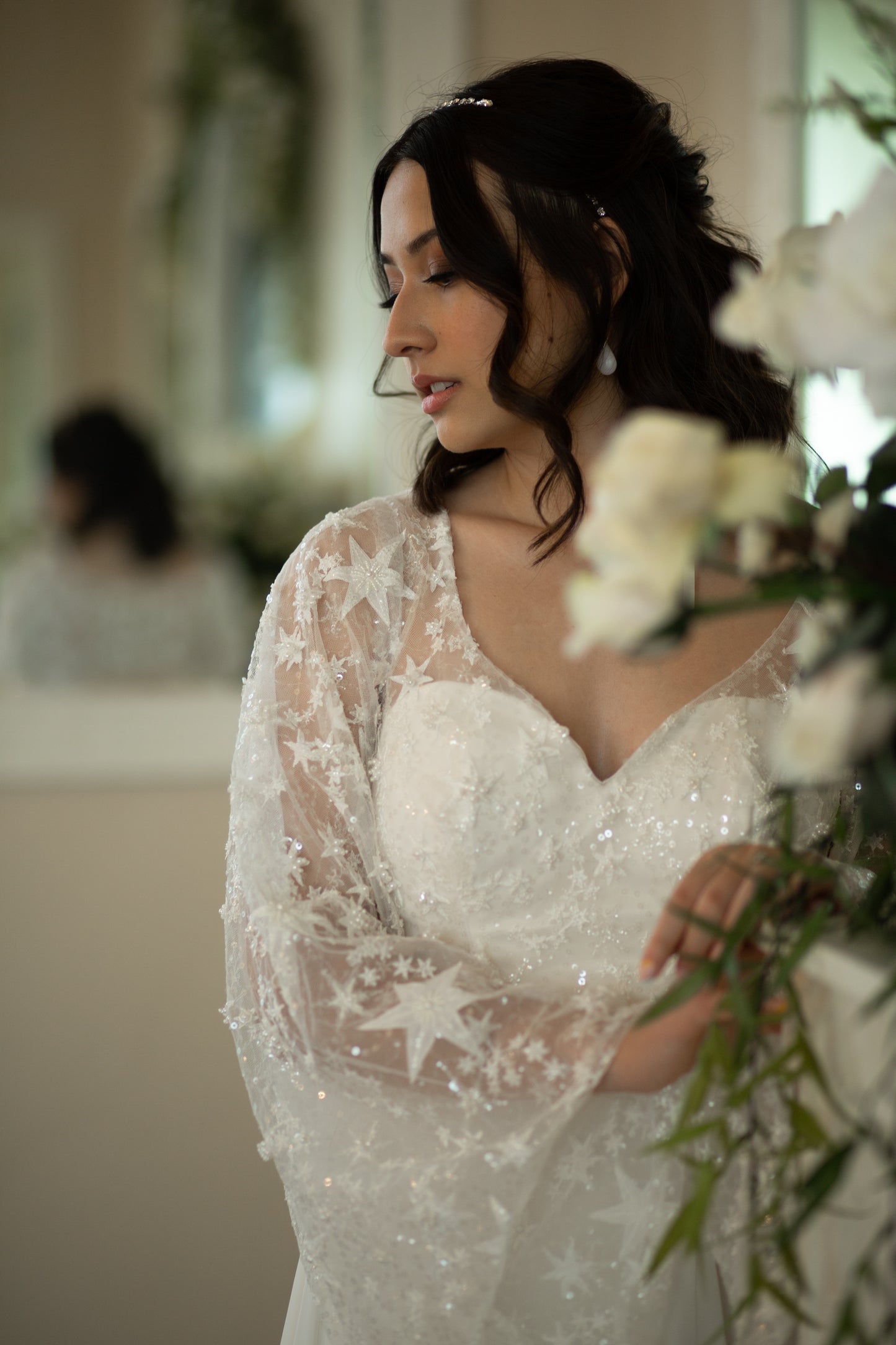 Detail of bell sleeve on Novelli dress featuring flowing chiffon and embroidered stars