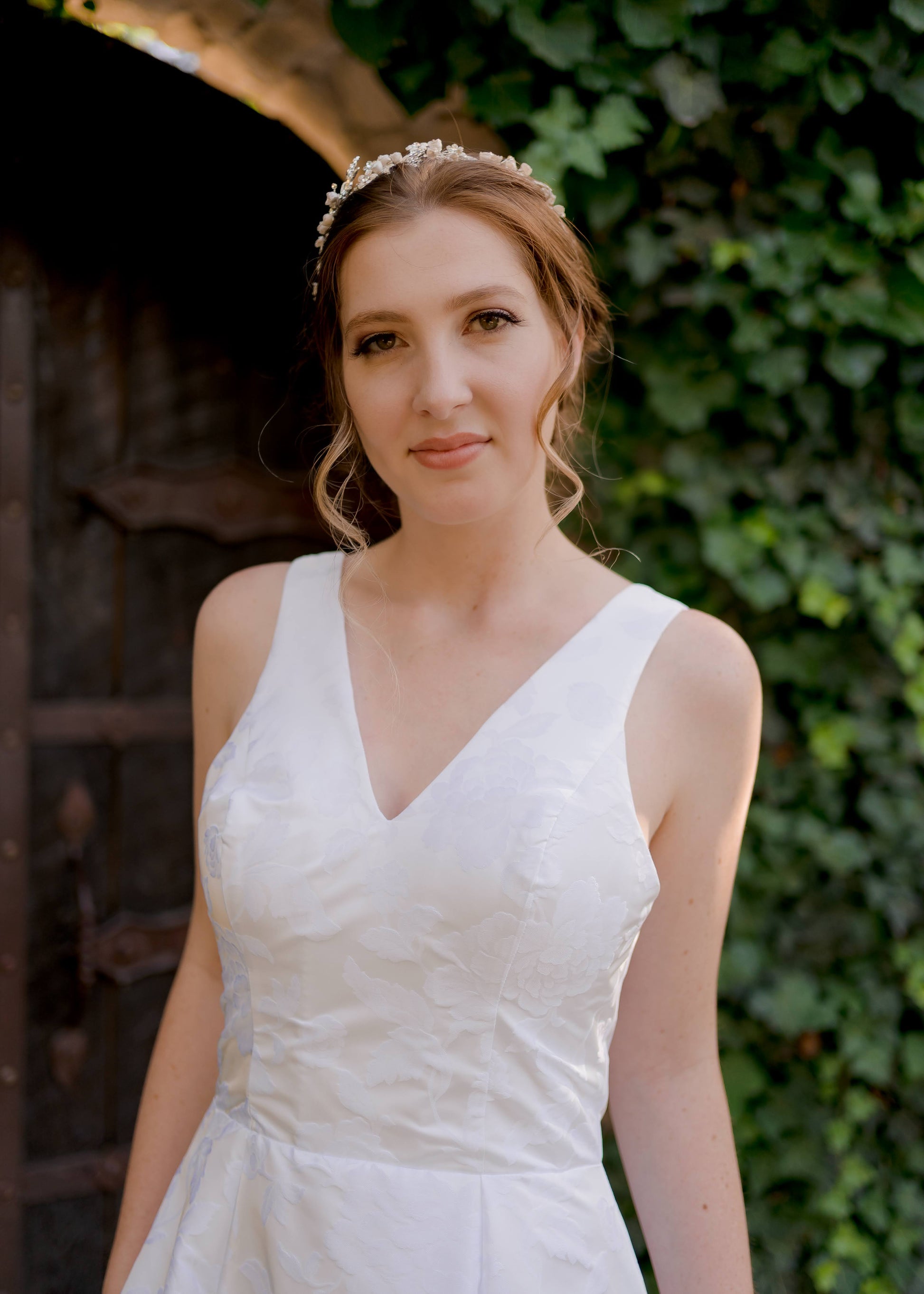A close up of the front bodice of a bride wearing the madison gown; Subtle princess seam and shoulder strap placement on jacquard gown are supportive and flattering. 