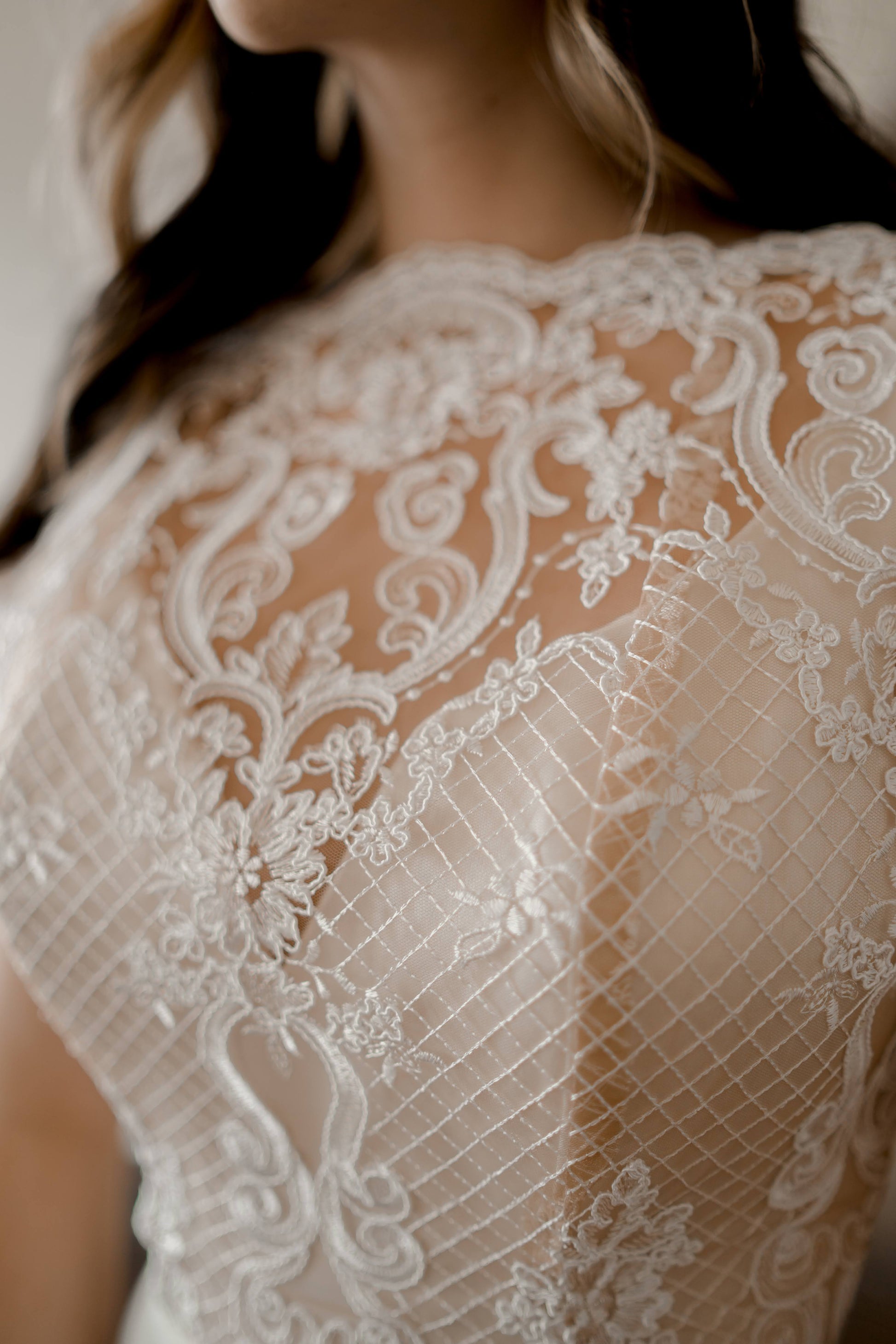 A micro shot of the lace on the winifred front bodice with the deep satin sweetheart, wide mock neck lace edge, and ivory floral lace details against the nude tulle. 