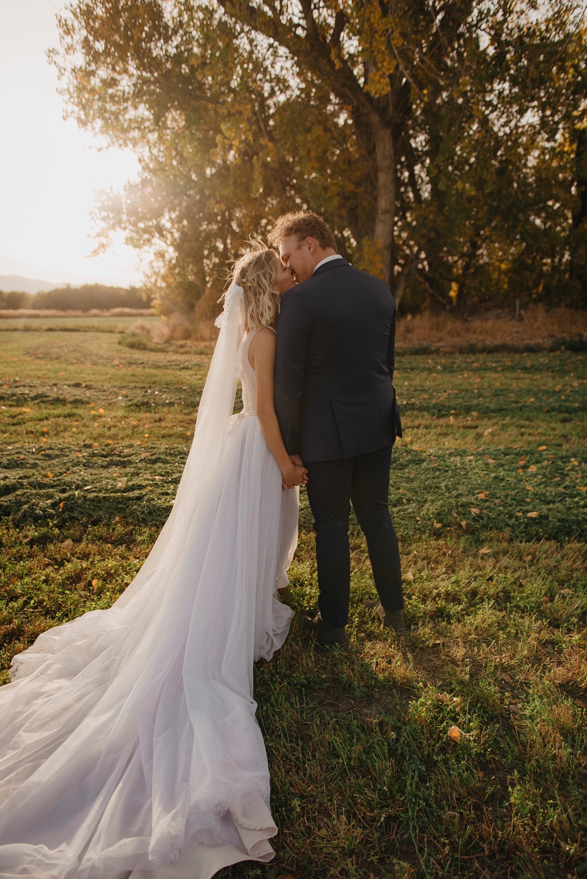 A styled shot of the persephone gown without a petticoat. The gahtered skirt is the foal point of this gown with the 33-inch tulle train spreading elegantly behind it. It has been paired with our Sharon veil in a chapel length. 