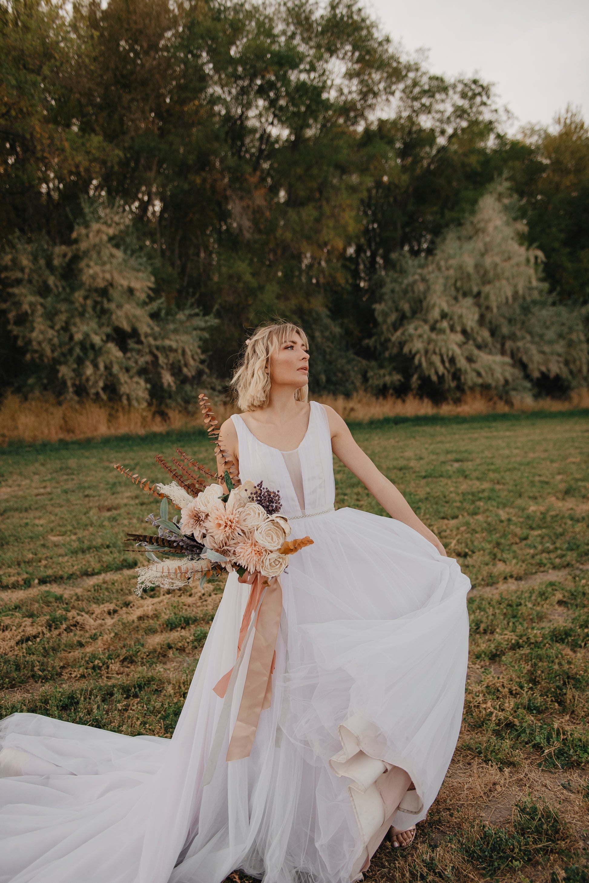 A shot of a bride wearing the persephone bridal gown, without a petticoat, she is dancing, moving the flowing tulle skirt back and forth. 